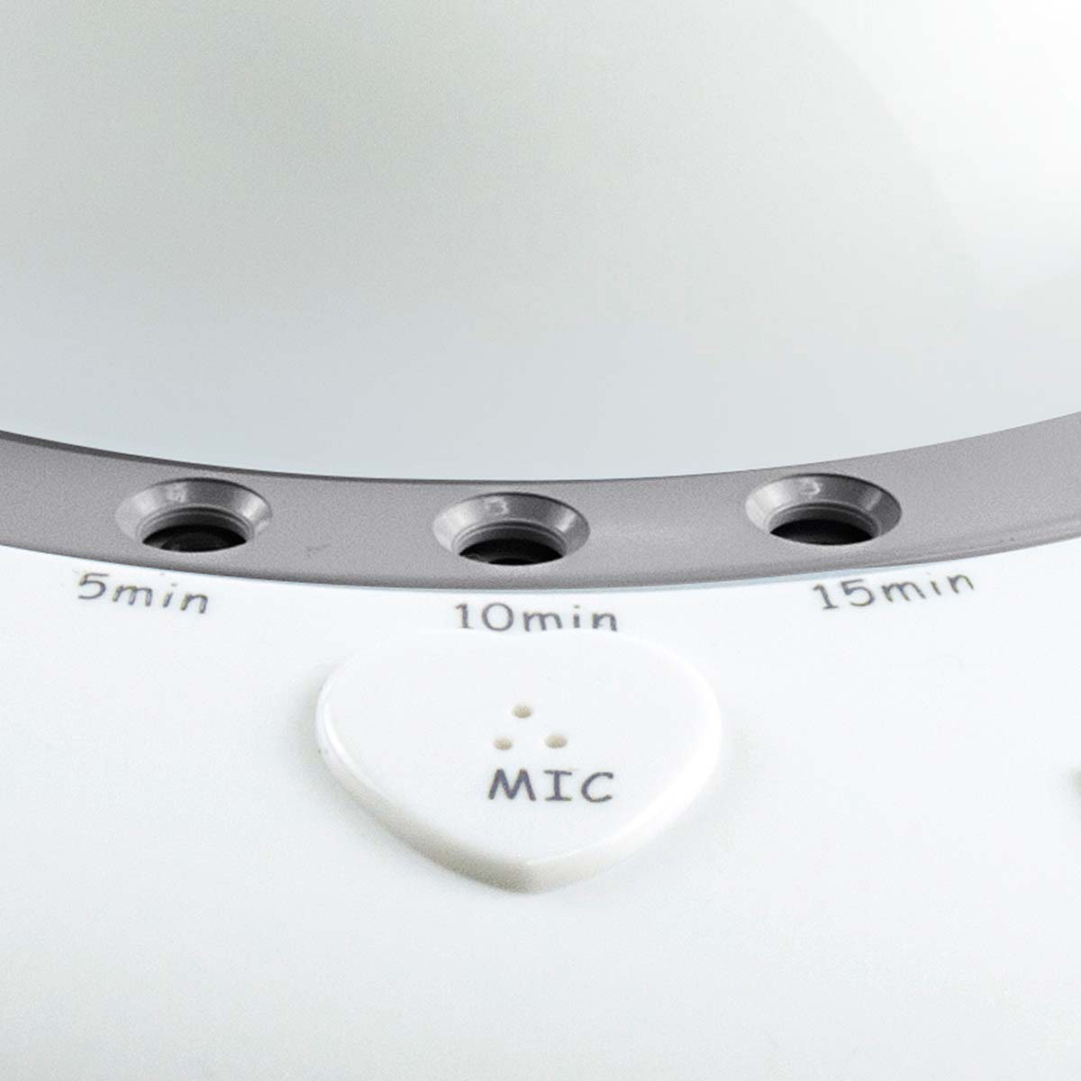 Un dispositivo bianco con inserto argentato, indicatori di timer da 5, 10, 15 min e un pulsante a forma di cuore con la scritta MIC.