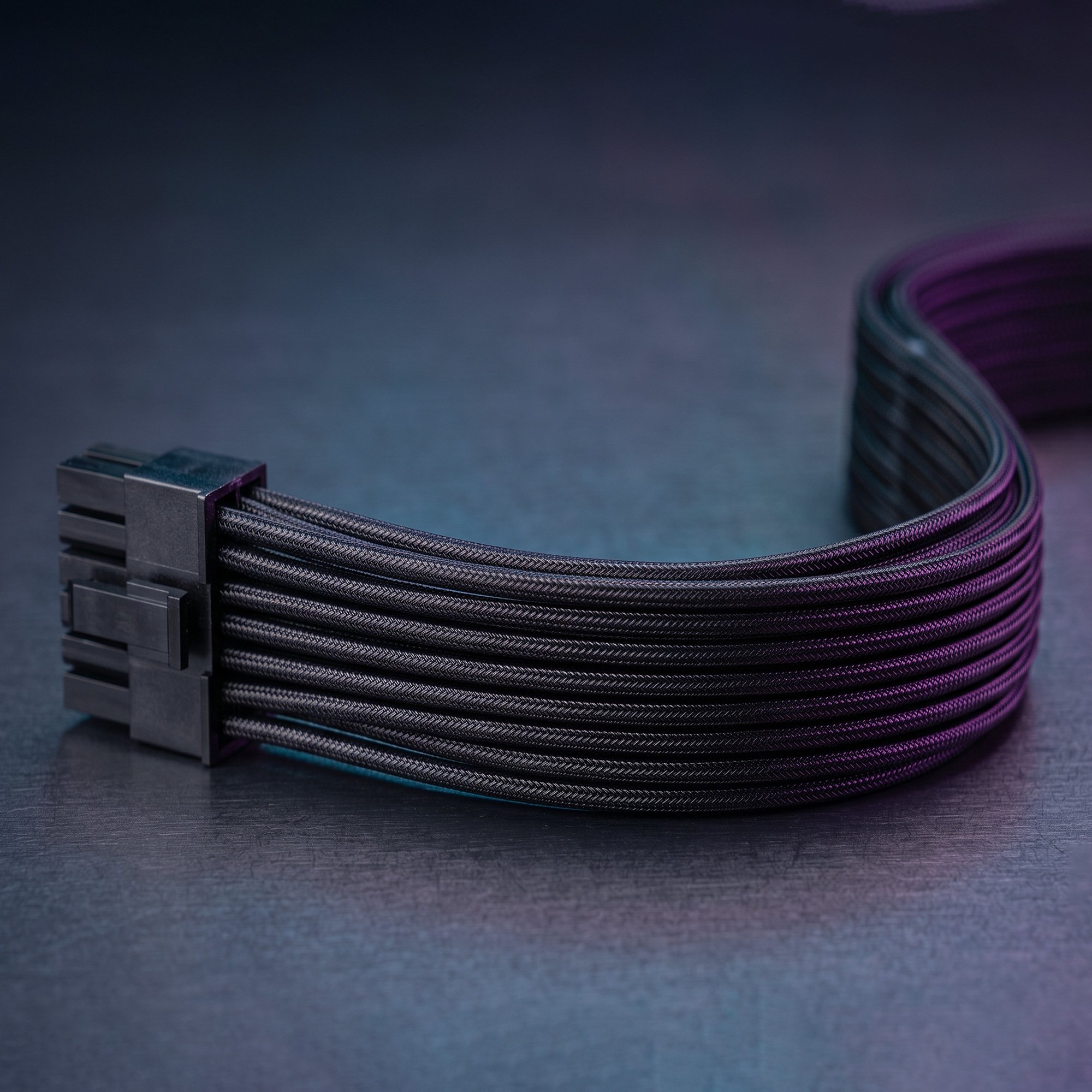 Un cable de alimentación trenzado negro con un conector yace curvado sobre una superficie oscura, iluminado con luz púrpura.