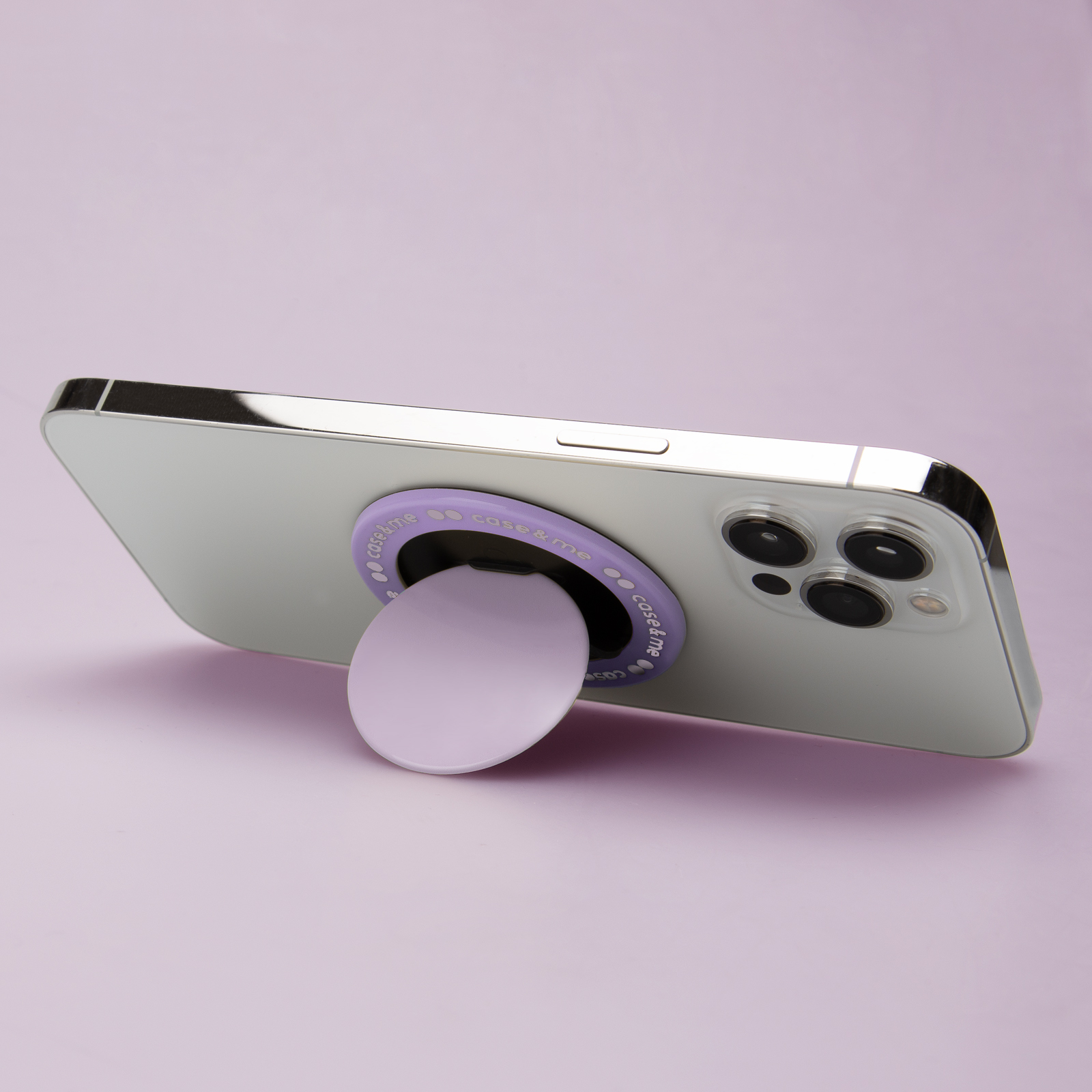 Un teléfono inteligente se encuentra sobre un fondo morado con un soporte morado en la parte trasera.