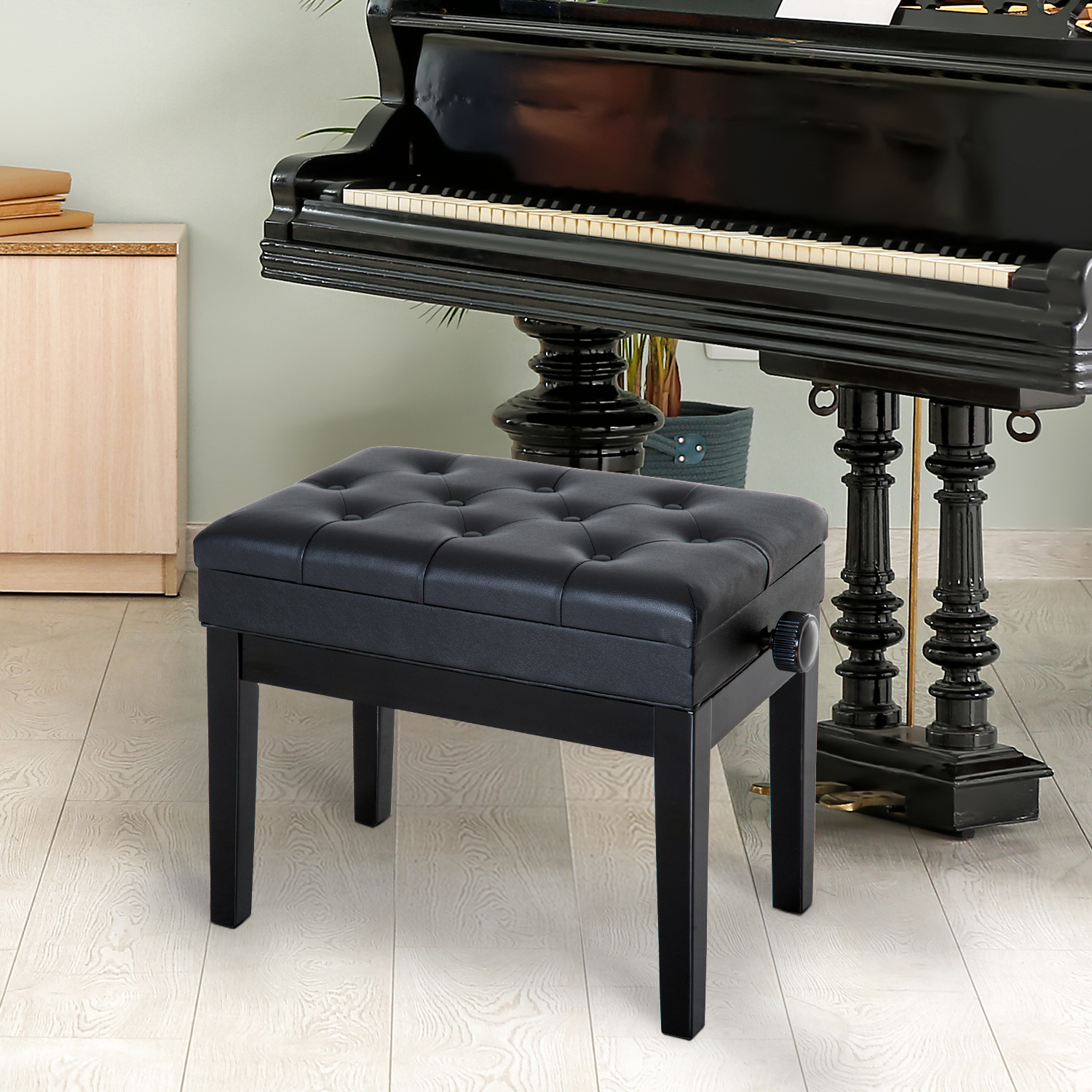Un banco de piano negro capitoné se encuentra frente a un piano de cola negro en un piso de madera clara.