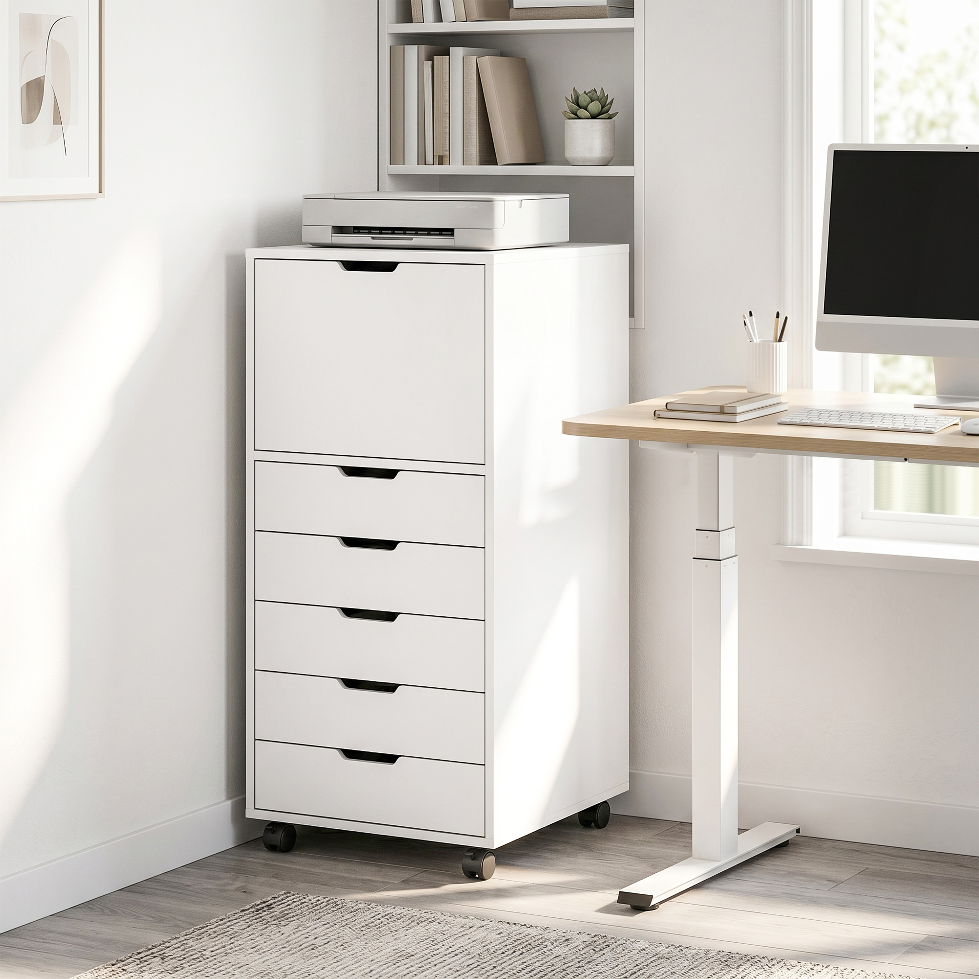 Un gavetero blanco con ruedas se encuentra en una habitación junto a un escritorio con una computadora.