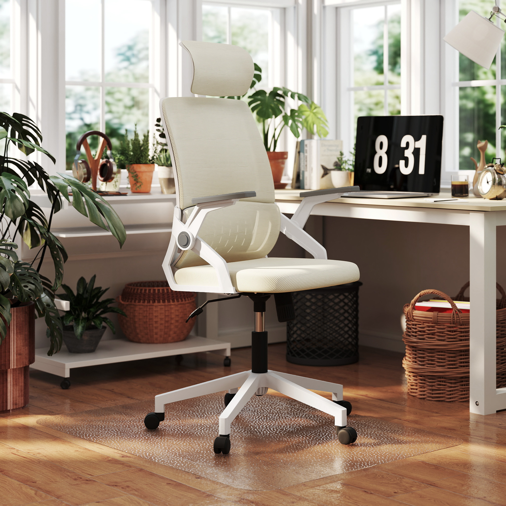 Una silla de oficina ergonómica blanca en un estudio luminoso con plantas y un escritorio con portátil.
