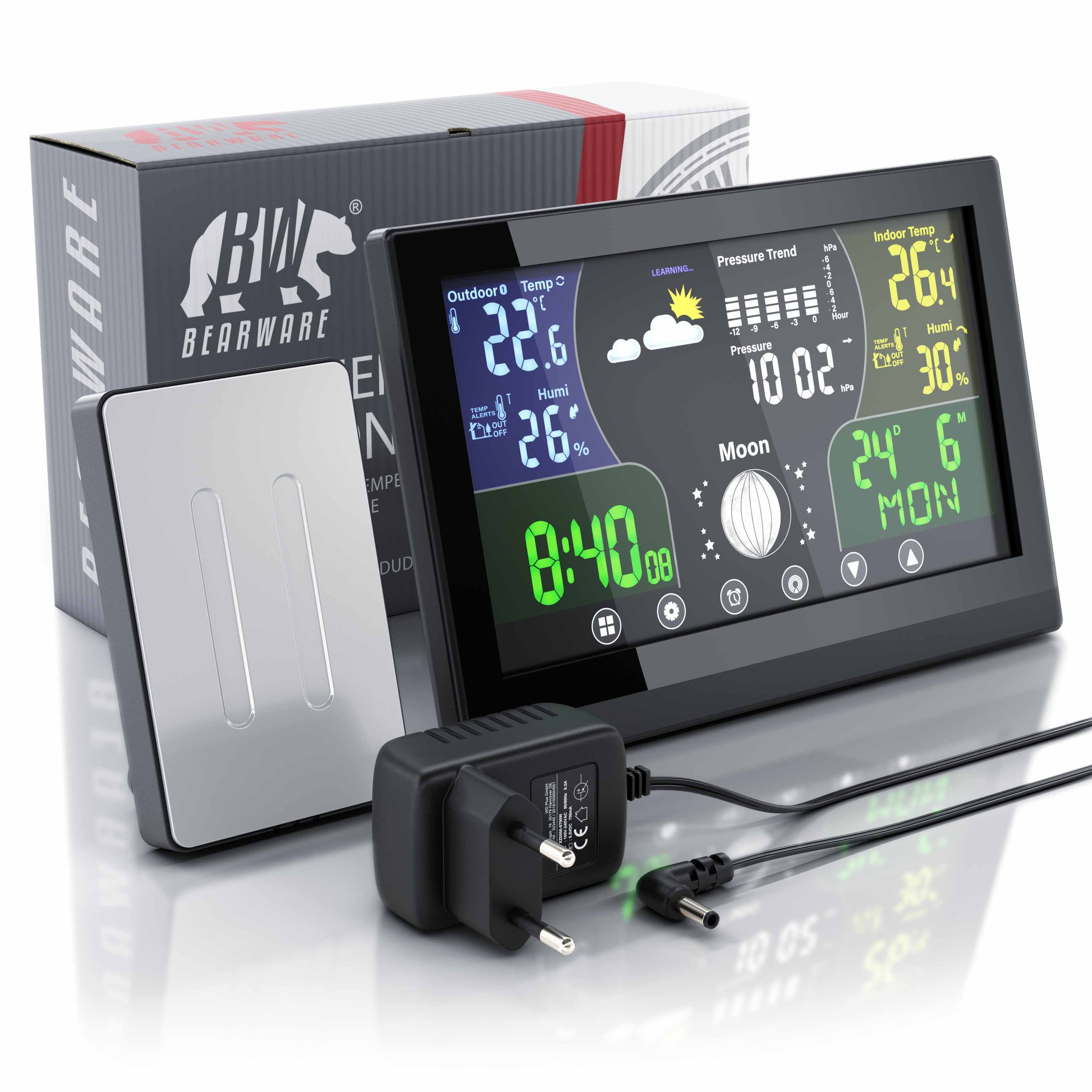 Wetterstation mit farbigem Display, Außensensor, Netzteil und Verpackung auf weißem Grund.