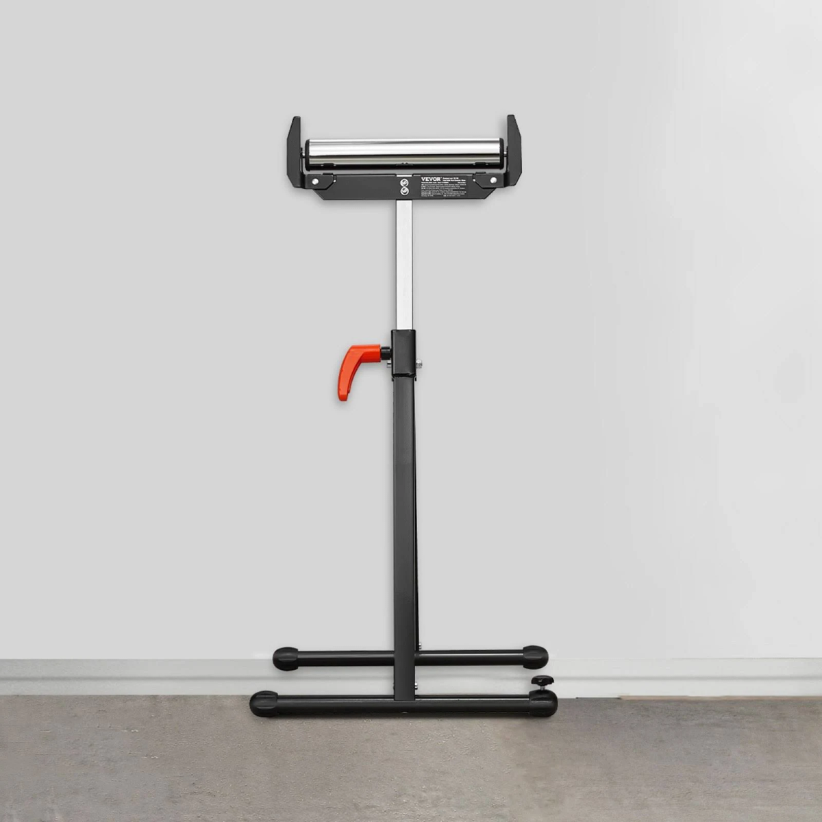 Soporte de rodillo ajustable en negro y plateado con mango naranja contra una pared gris.