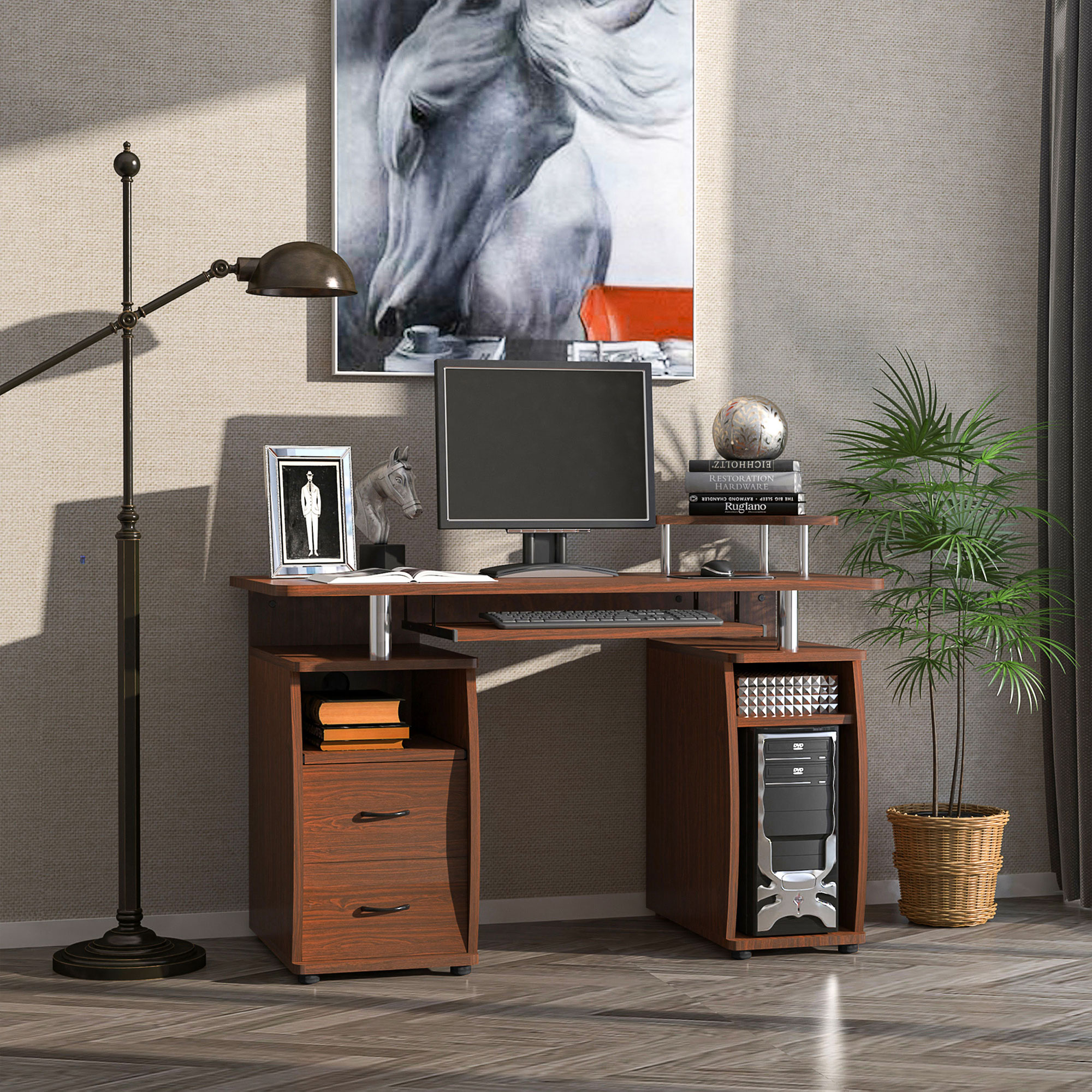 Una scrivania in legno con computer, lampada, opera d'arte, libri e pianta in vaso.