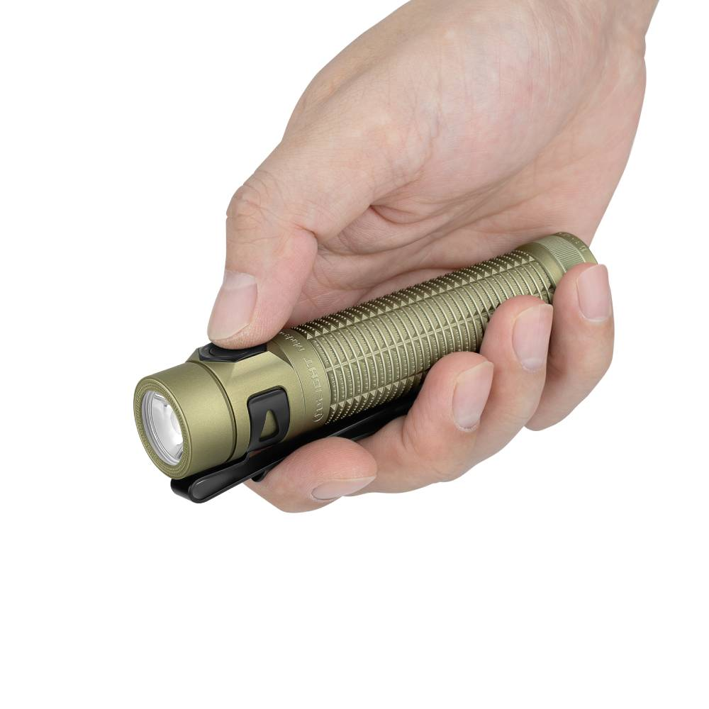 Una mano sosteniendo una linterna compacta verde oliva con clip sobre fondo blanco.