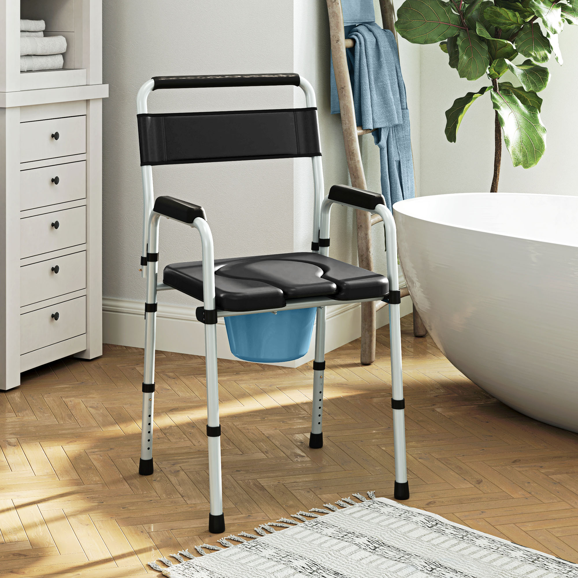 Una silla con inodoro, marco de metal plateado, asiento negro y cubo azul en un baño.