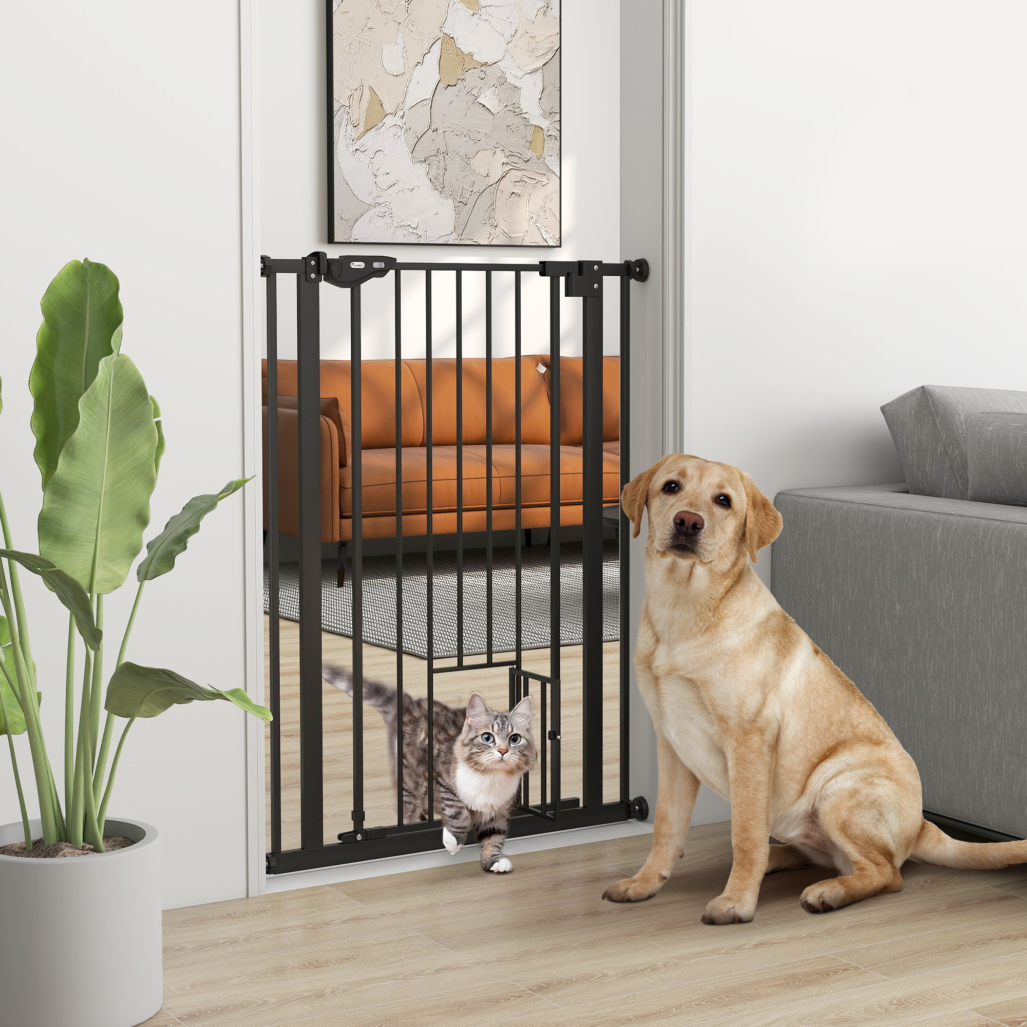 Un labrador amarillo se sienta frente a una puerta para mascotas mientras un gato pasa por una puerta pequeña.