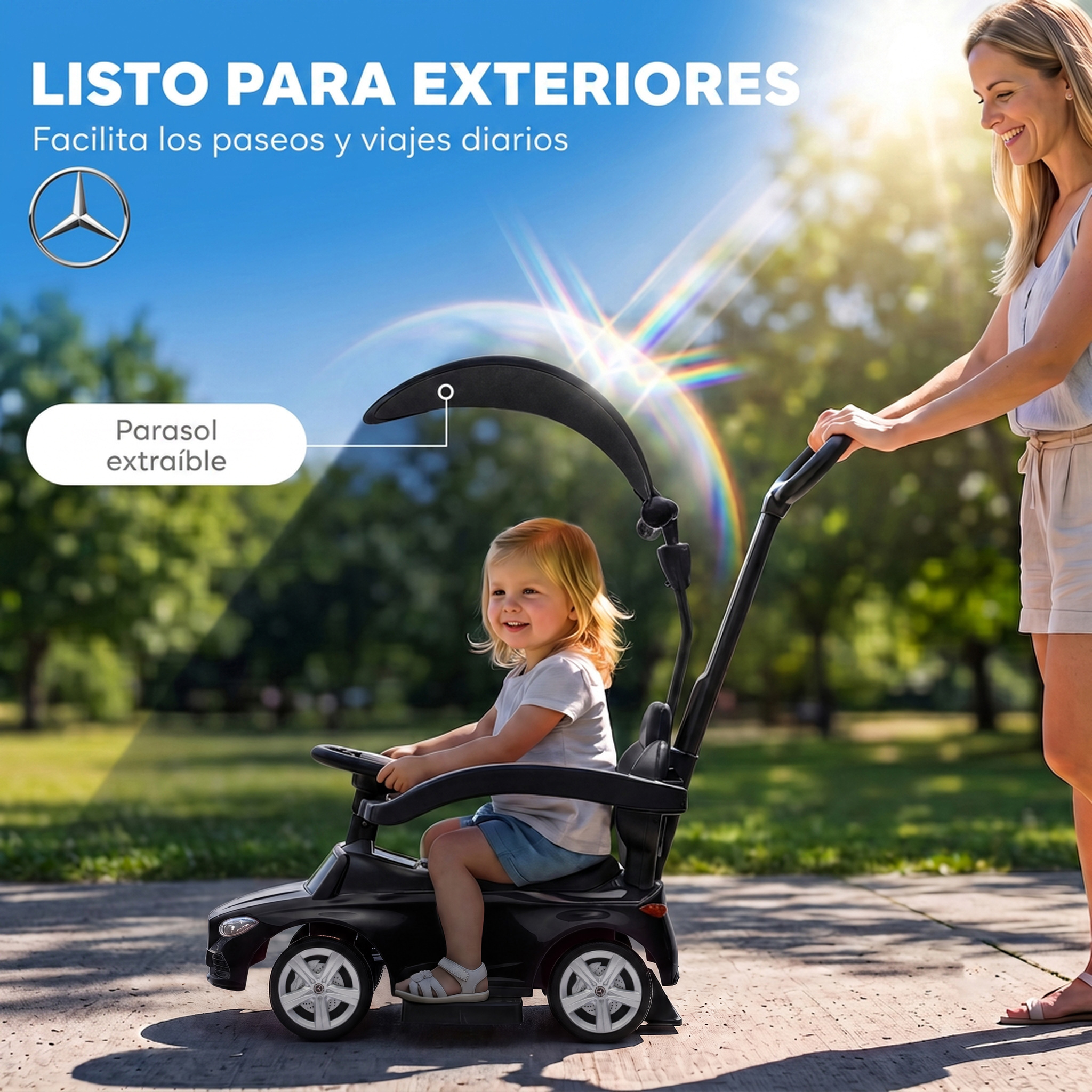 Una mujer empuja a un niño sonriente en un cochecito negro de Mercedes en un parque soleado.