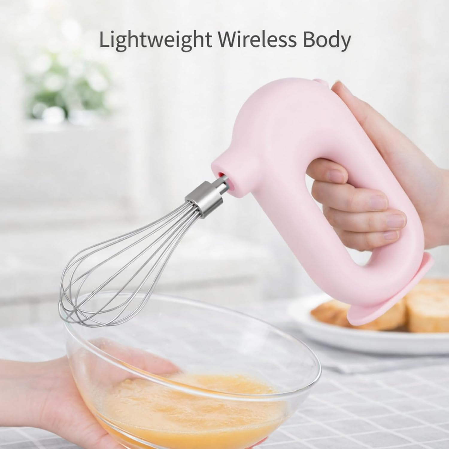 Hand hält einen rosa Handmixer über einer durchsichtigen Schüssel mit Teig.