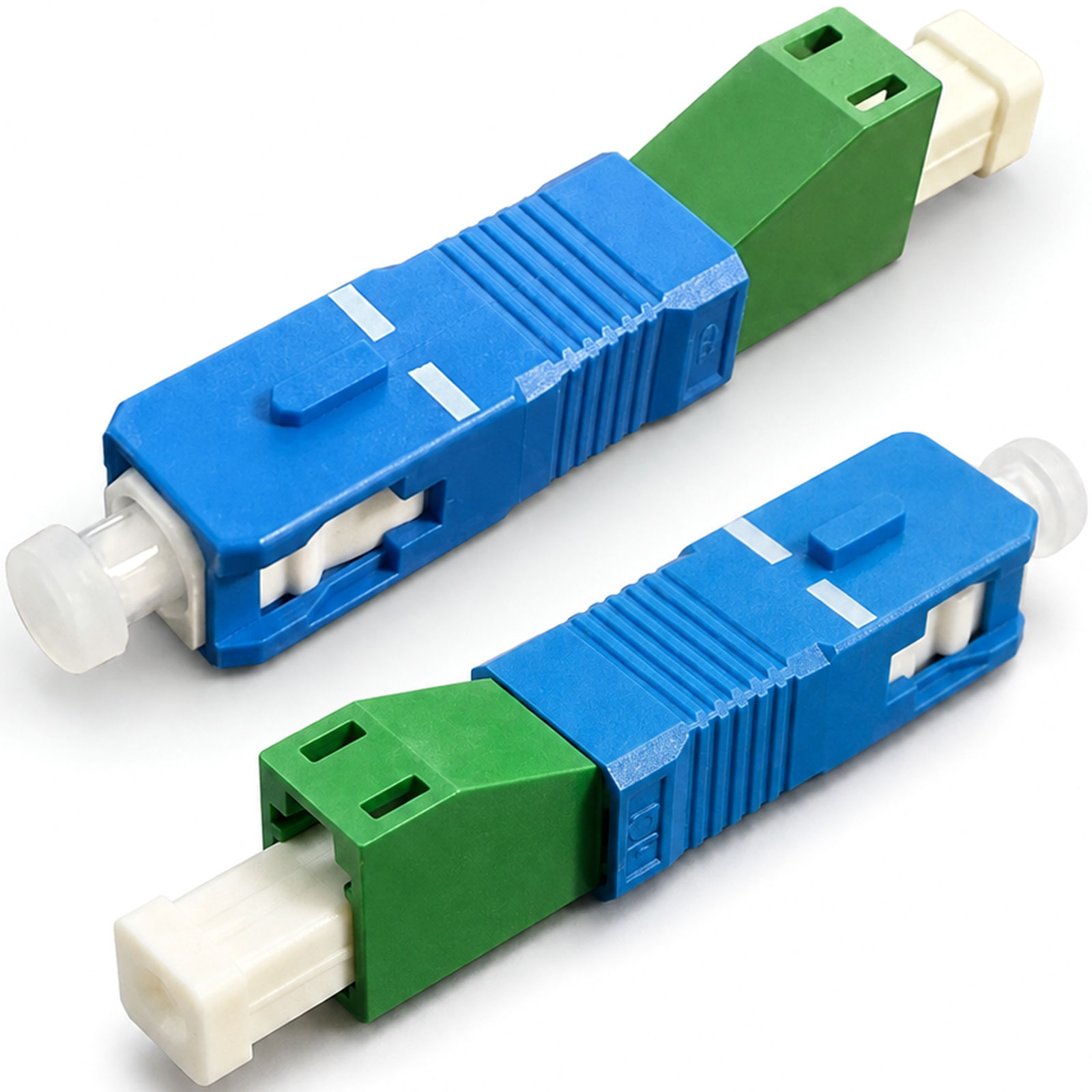 Zwei blau-grüne SC-Glasfaseradapter liegen schräg auf einer weißen Oberfläche.