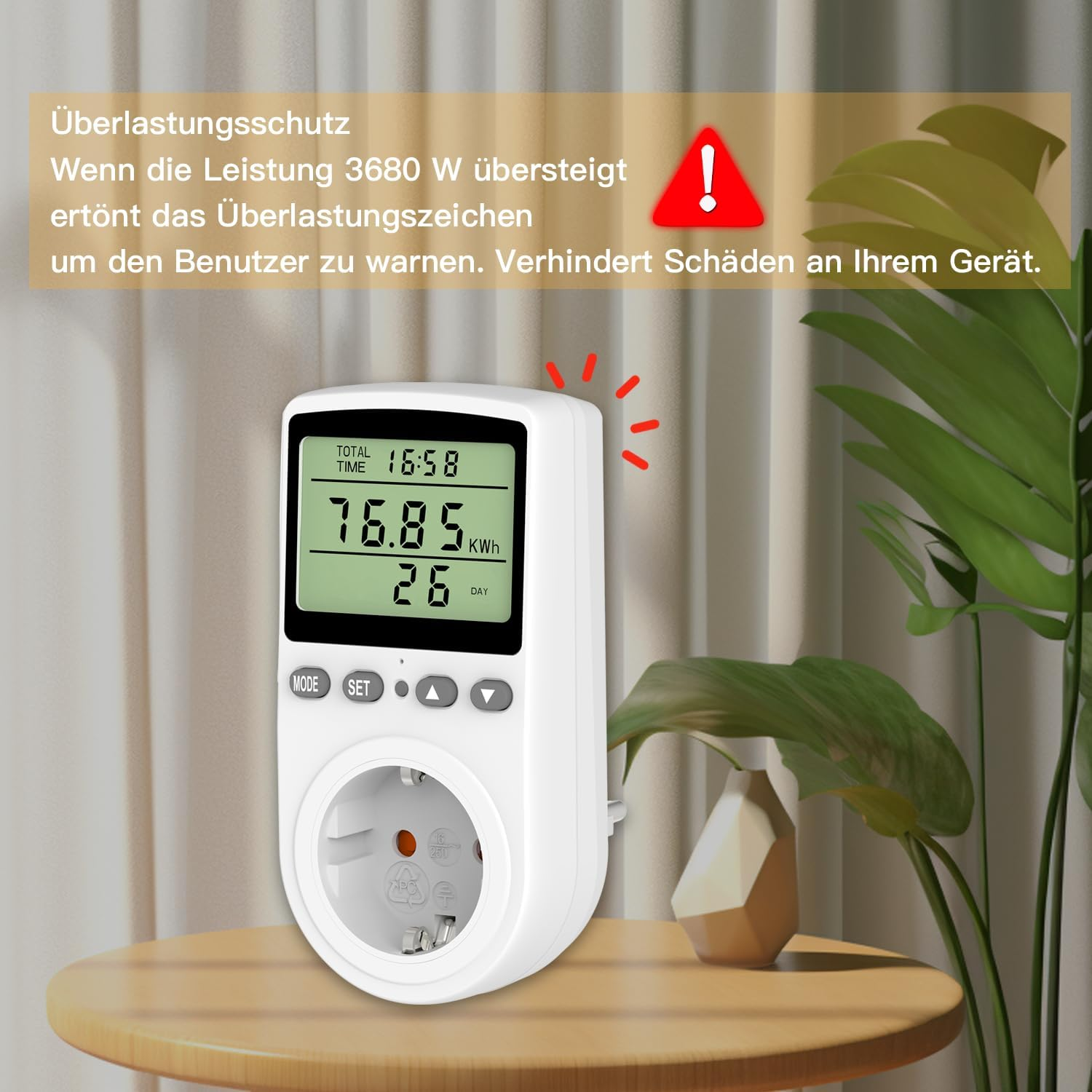 Ein weißes Energiemessgerät auf einem Tisch mit deutscher Warntexttafel.
