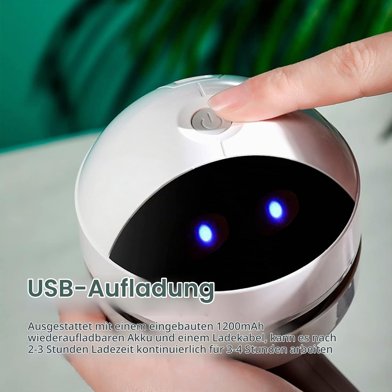 Finger drückt den Einschaltknopf eines runden weißen Geräts mit blauen leuchtenden Augen und USB-Text.