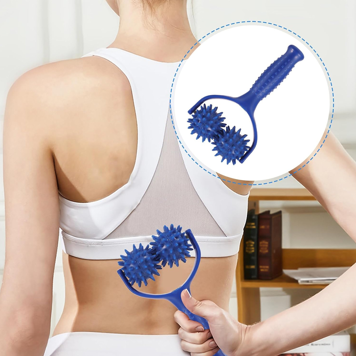 Eine Frau in weißer Sportkleidung massiert ihren Rücken mit einem blauen Massagegerät mit Stacheln.