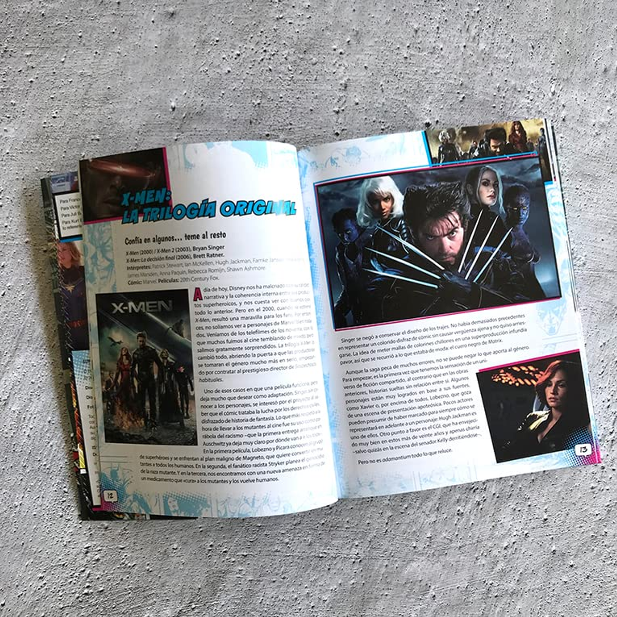 Una revista abierta sobre una superficie gris texturizada muestra artículos e imágenes de X-Men.