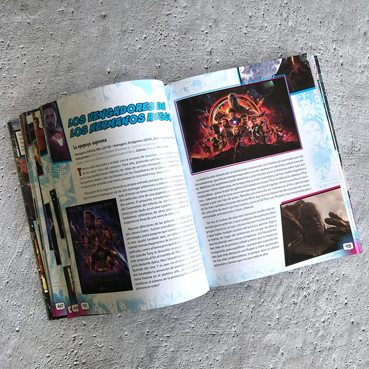 Una revista abierta con imágenes de Marvel Avengers y texto sobre una superficie gris.