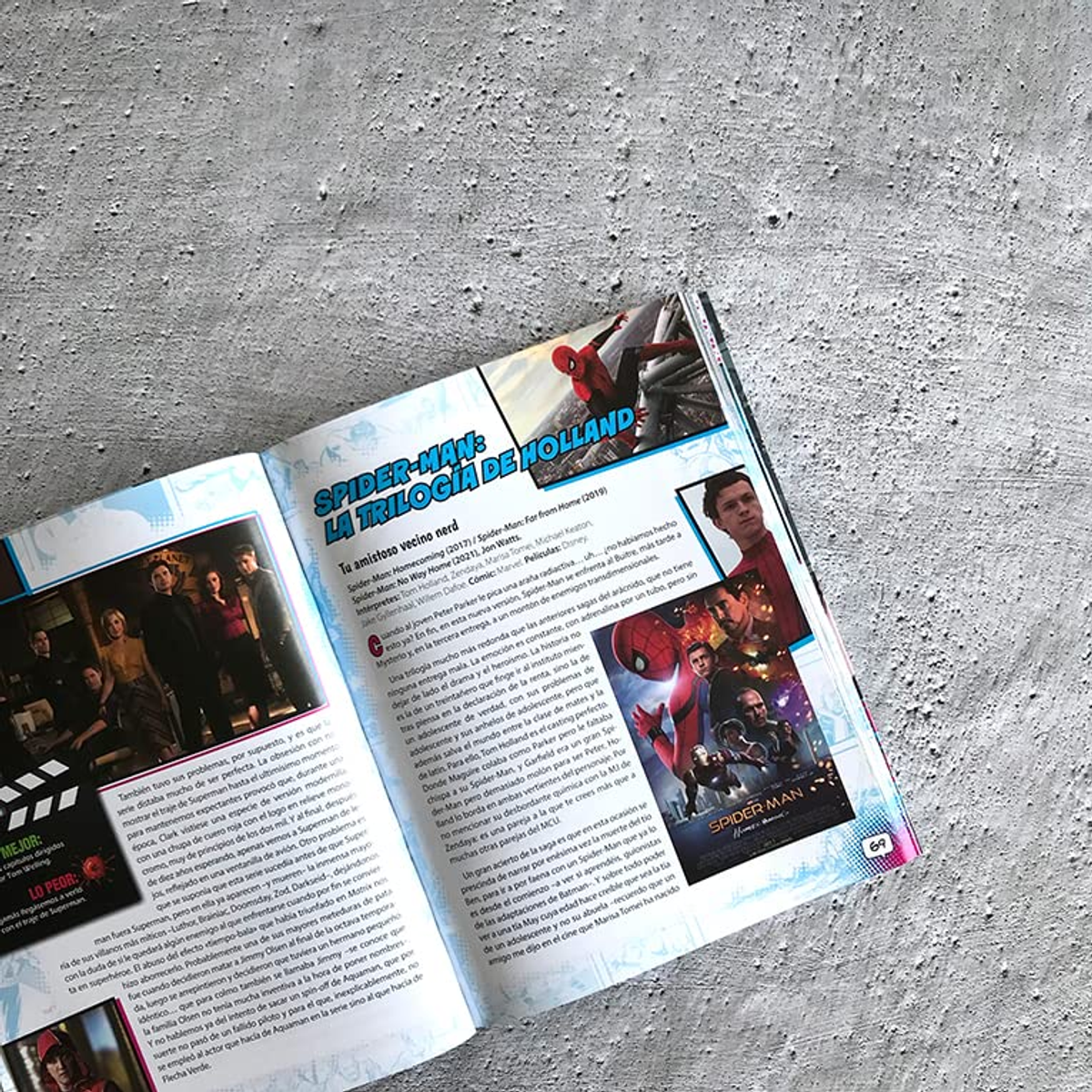 Una revista abierta yace sobre una superficie de hormigón gris rugoso, mostrando páginas sobre Spider-Man.