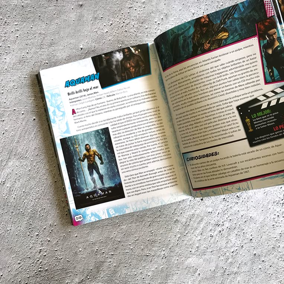 Revista abierta con artículos sobre la película Aquaman en una mesa de madera blanca.