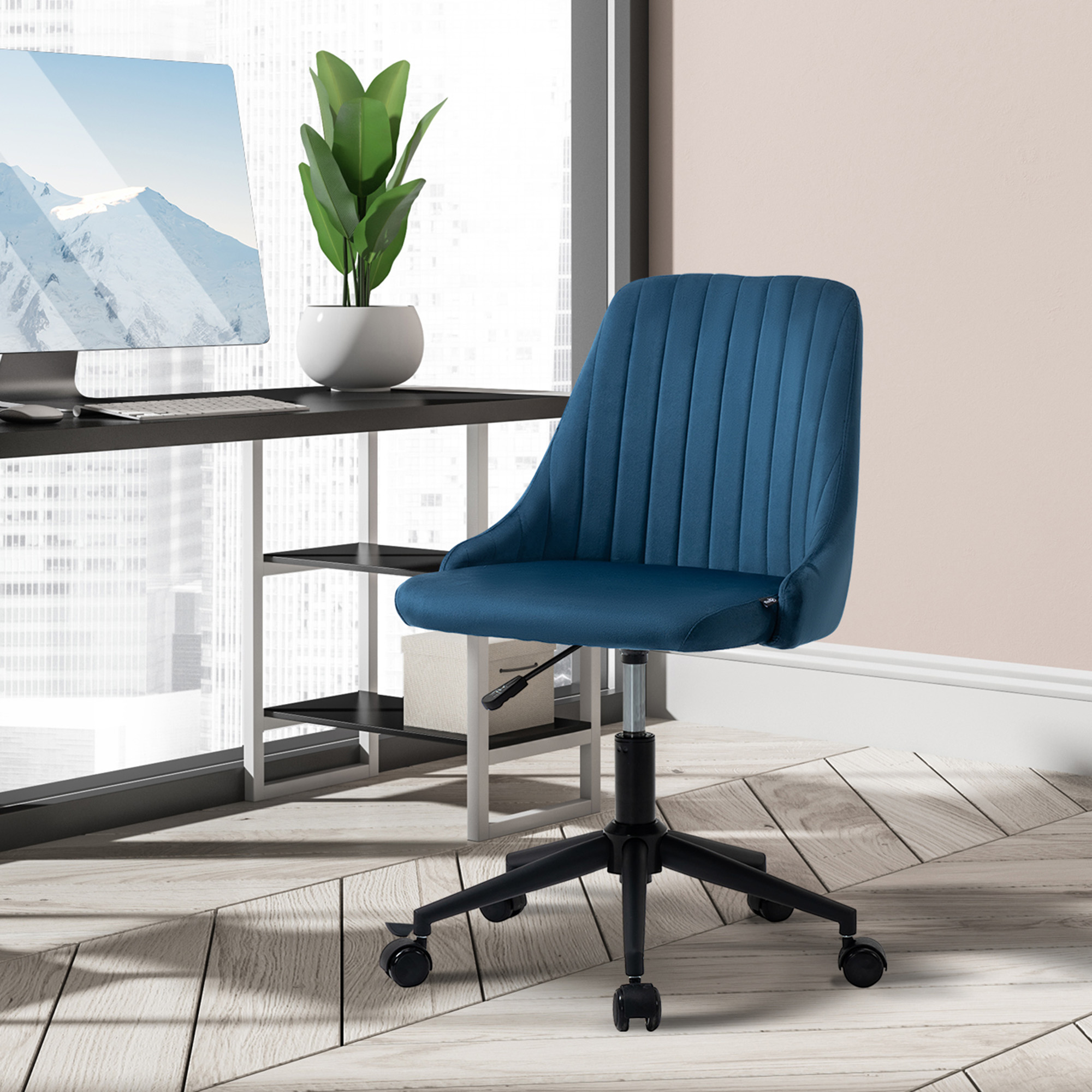 Una sedia da ufficio imbottita blu con ruote nere si trova in una stanza moderna davanti a una scrivania con computer.