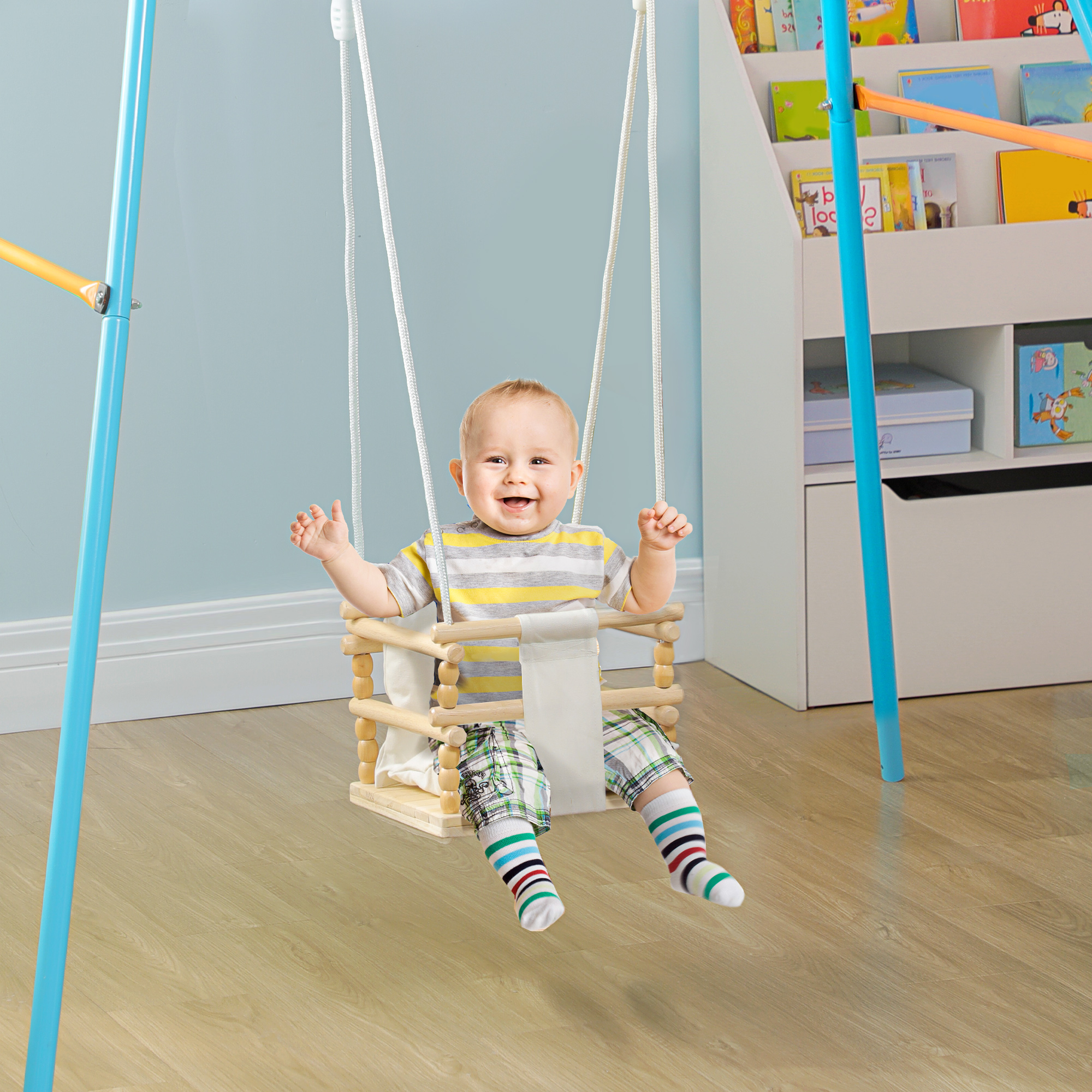 Un bambino sorridente su un'altalena di legno all'interno, con una libreria sullo sfondo.