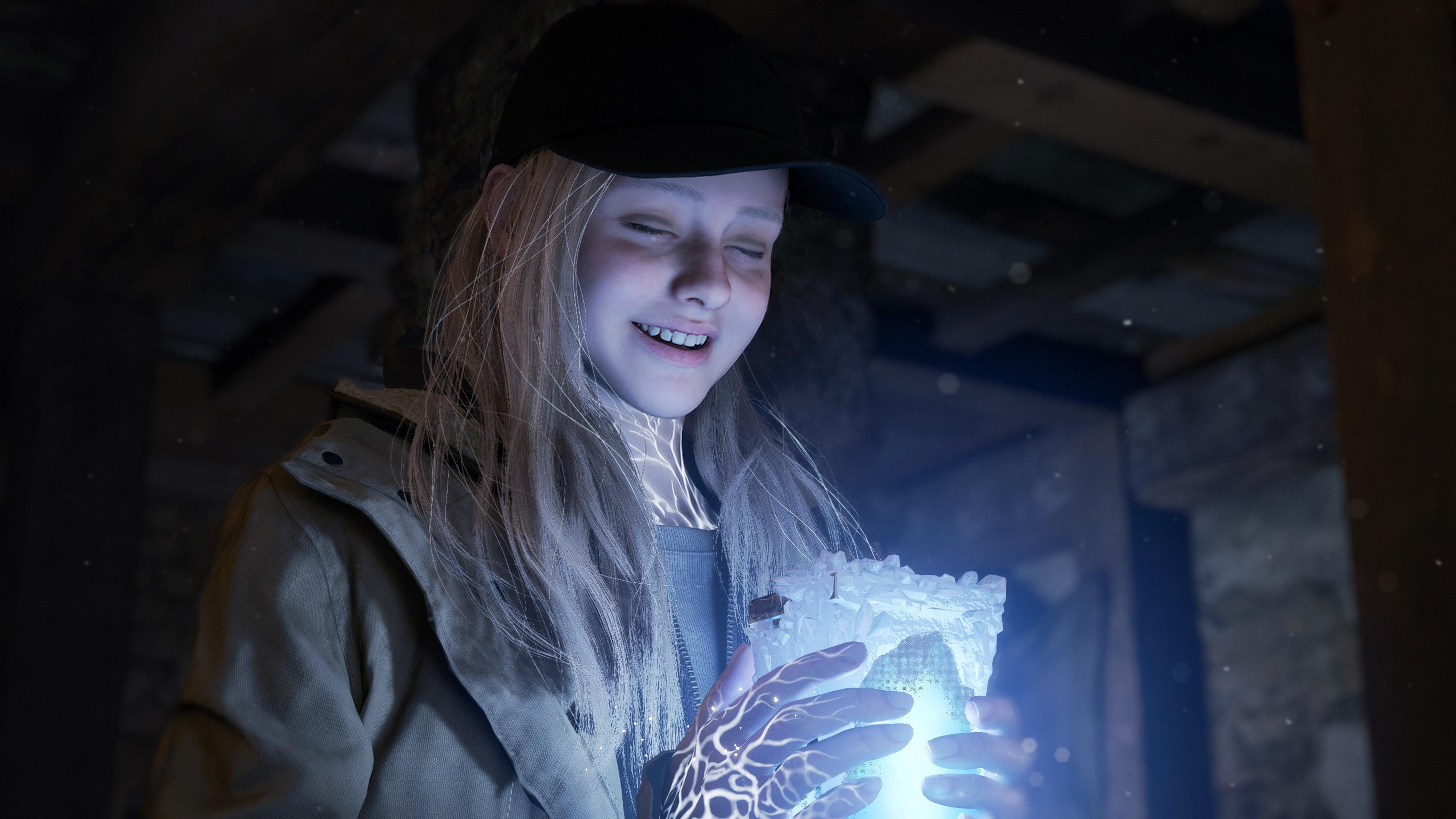 Ein blondes Mädchen in einer Kappe hält einen leuchtenden Kristall in den Händen, wobei magische Lichtmuster auf ihrer Haut reflektiert werden.