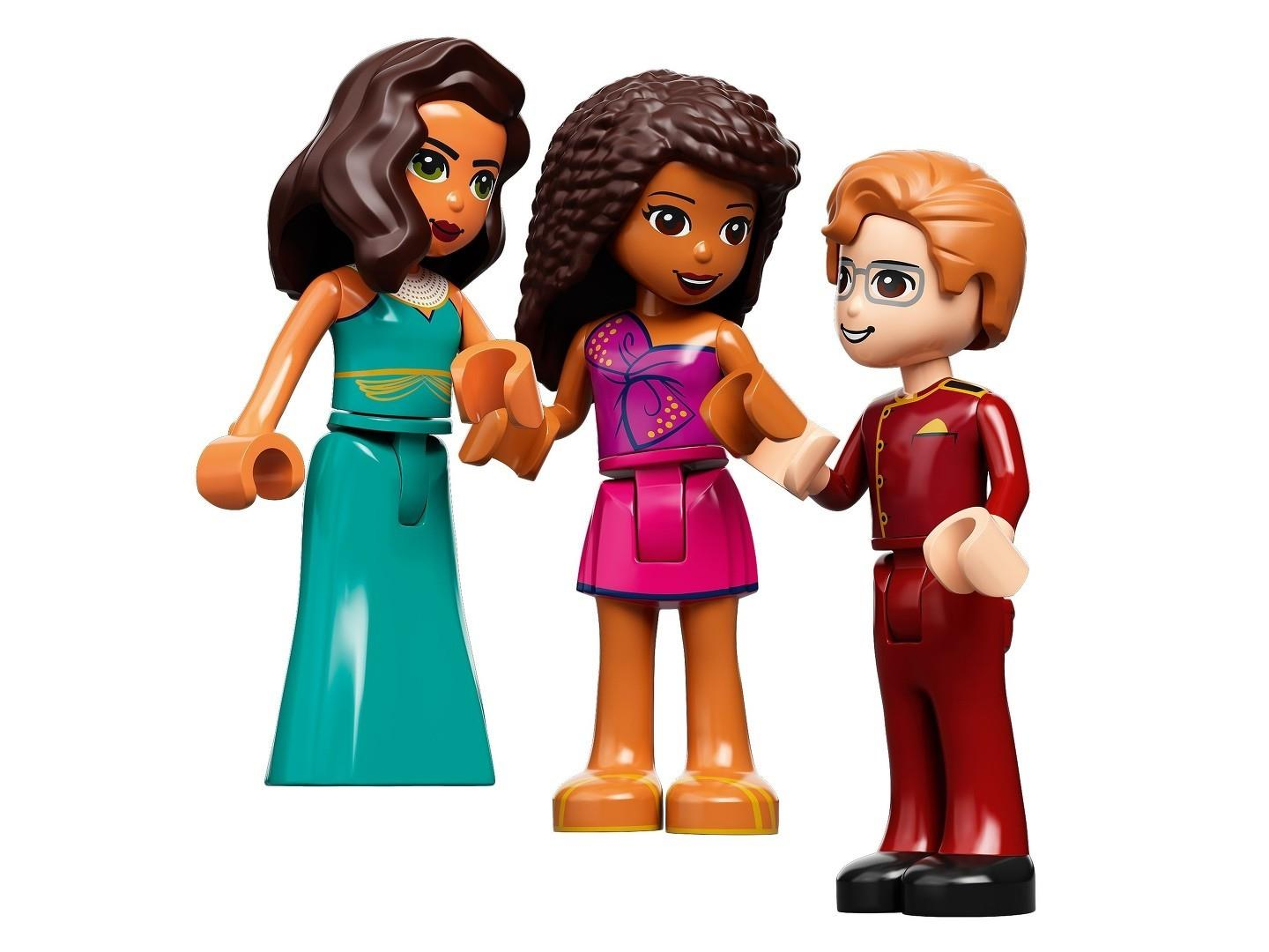 Drei Lego Friends Figuren in bunter Kleidung stehen auf weißem Hintergrund.