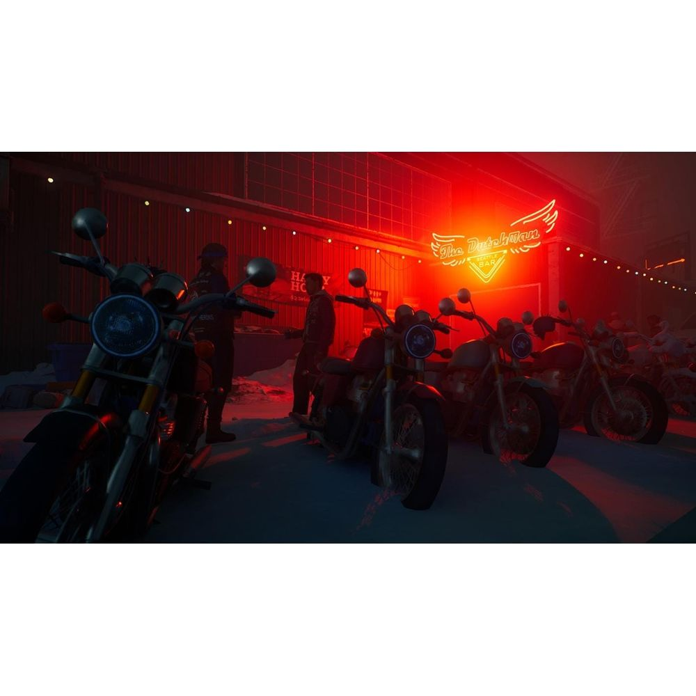 Diverse moto parcheggiate davanti a un bar illuminato di rosso di notte.