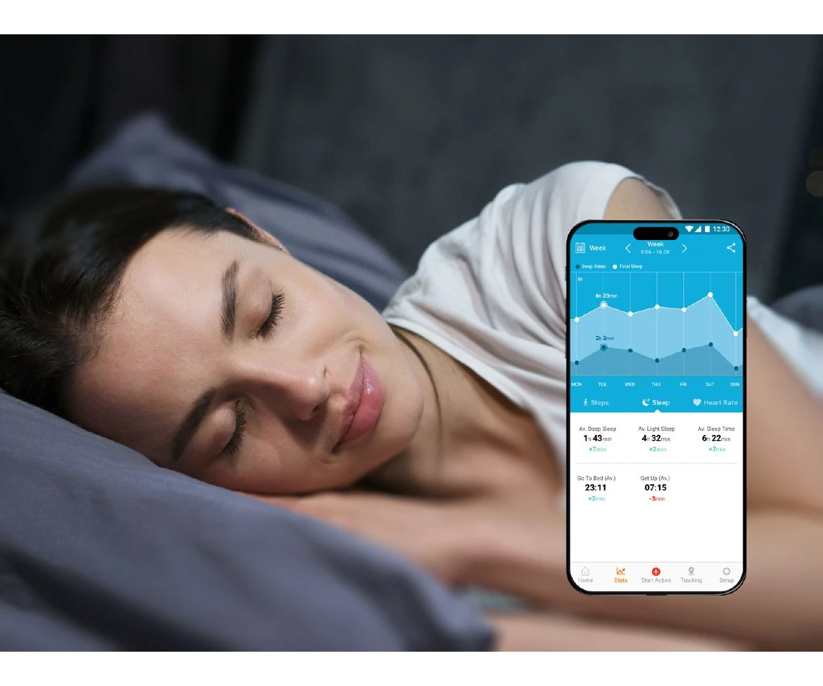 Młoda kobieta śpi spokojnie w łóżku, obok niej smartfon wyświetla aplikację do monitorowania snu.