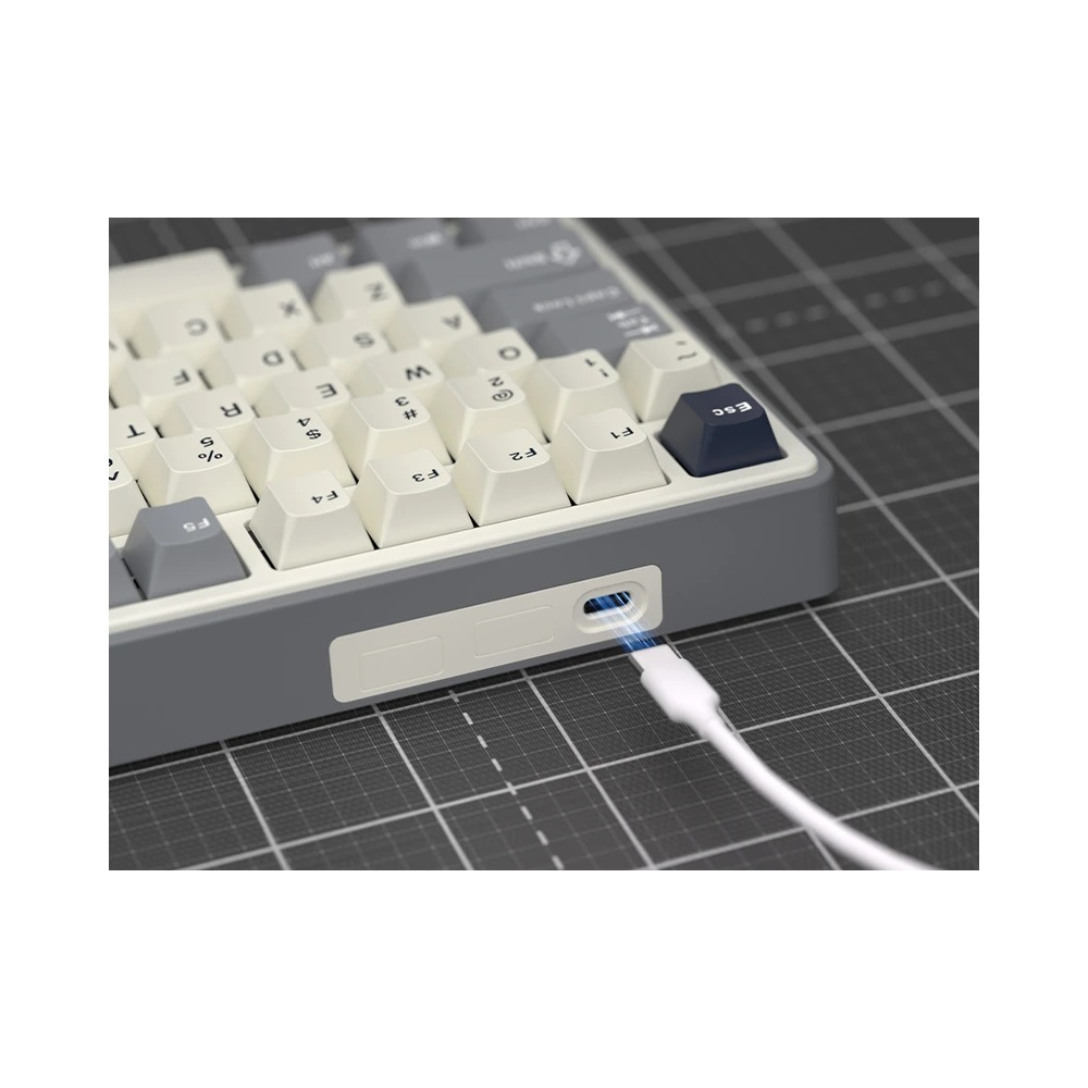 Biały kabel USB-C podłączony jest do tylnego portu szarej i kremowej klawiatury mechanicznej.