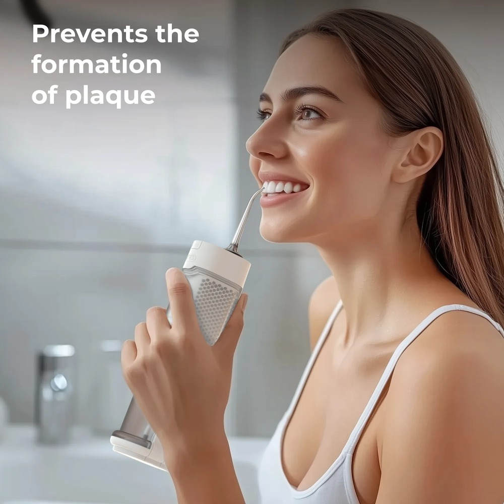 Una donna sorridente usa un idropulsore dentale bianco in bagno, con la scritta 'Previene la formazione di placca'.