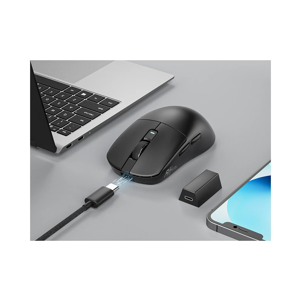 Gri masada, dizüstü bilgisayar ve akıllı telefonun yanında USB-C kablosuyla şarj edilen siyah kablosuz fare.