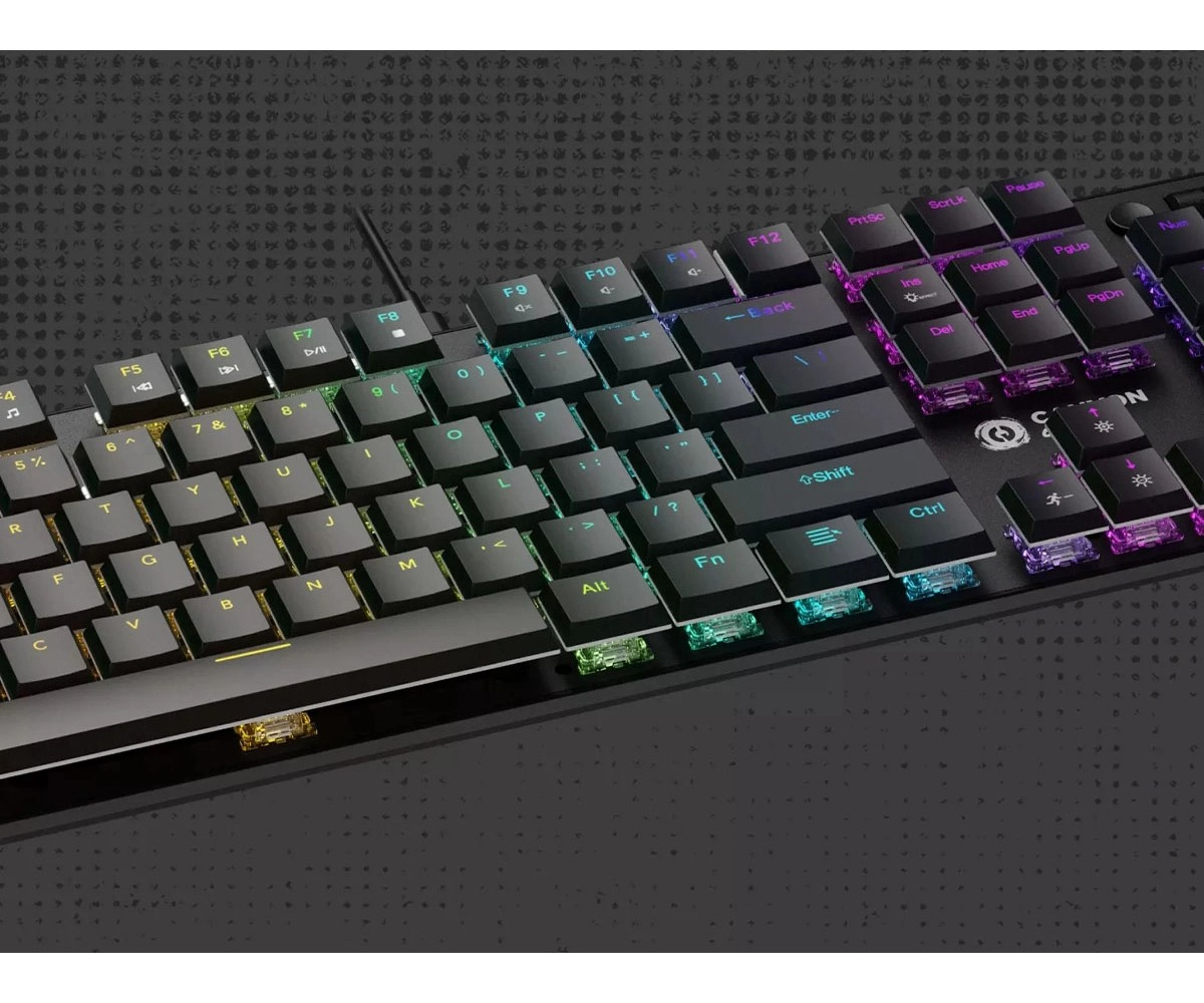 Czarna klawiatura mechaniczna z kolorowym podświetleniem RGB spoczywa na teksturowanej, ciemnej powierzchni.