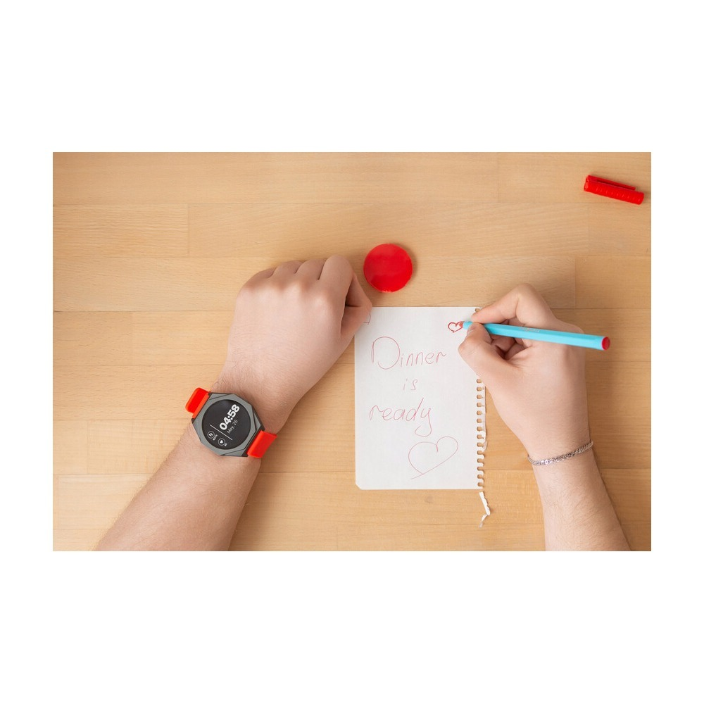 Osoba pisze "Dinner is ready" na notesie, mając na ręku smartwatch.
