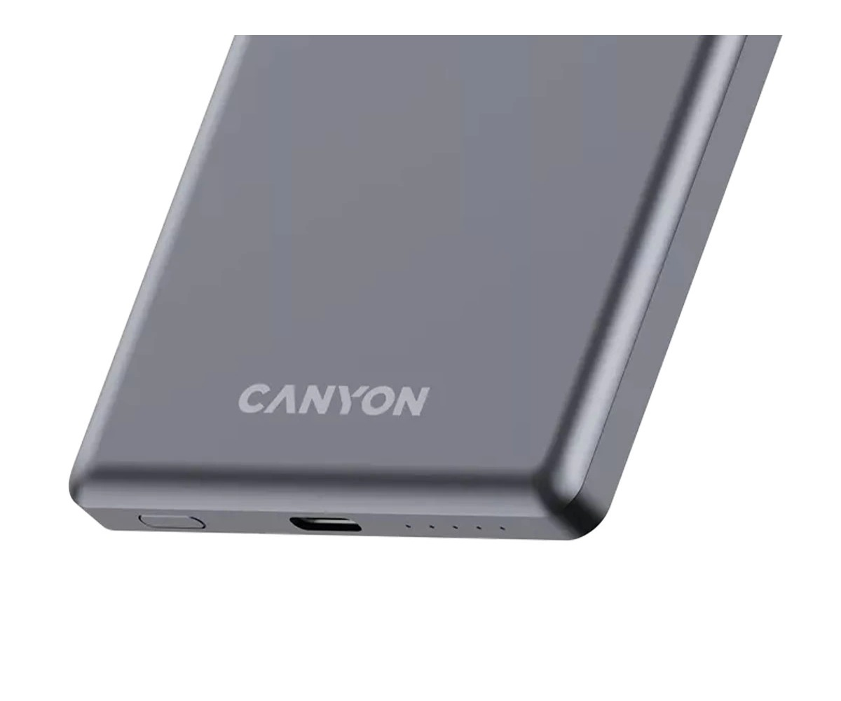 Zbliżenie szarego powerbanku Canyon z logo, portem USB, przyciskiem zasilania i lampkami kontrolnymi.