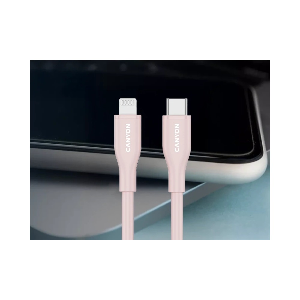 Dwa różowe kable ładujące Canyon ze złączami Lightning i USB-C przed laptopem.