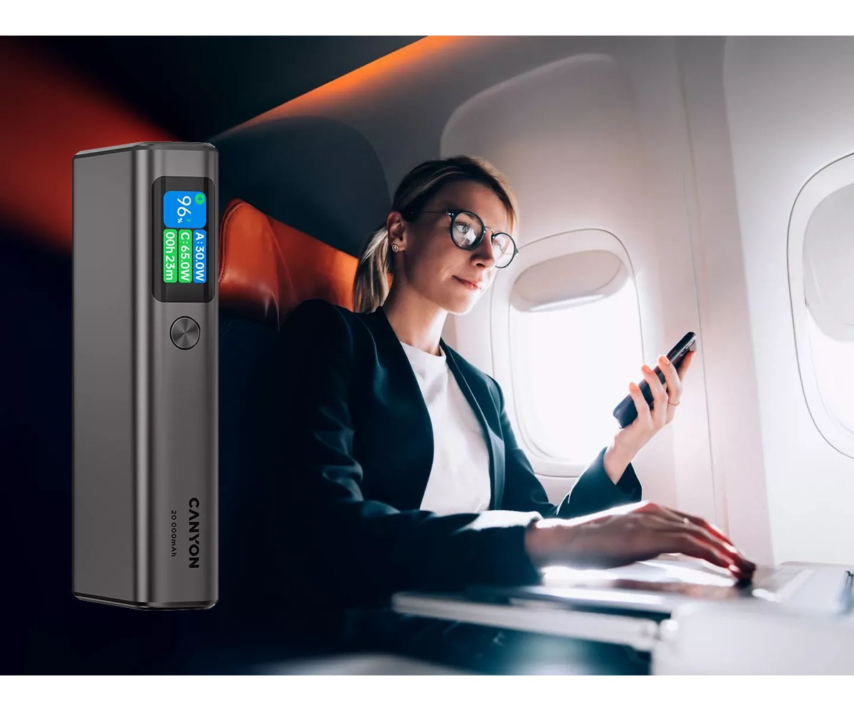 Powerbank Canyon obok kobiety korzystającej z telefonu i laptopa w samolocie.