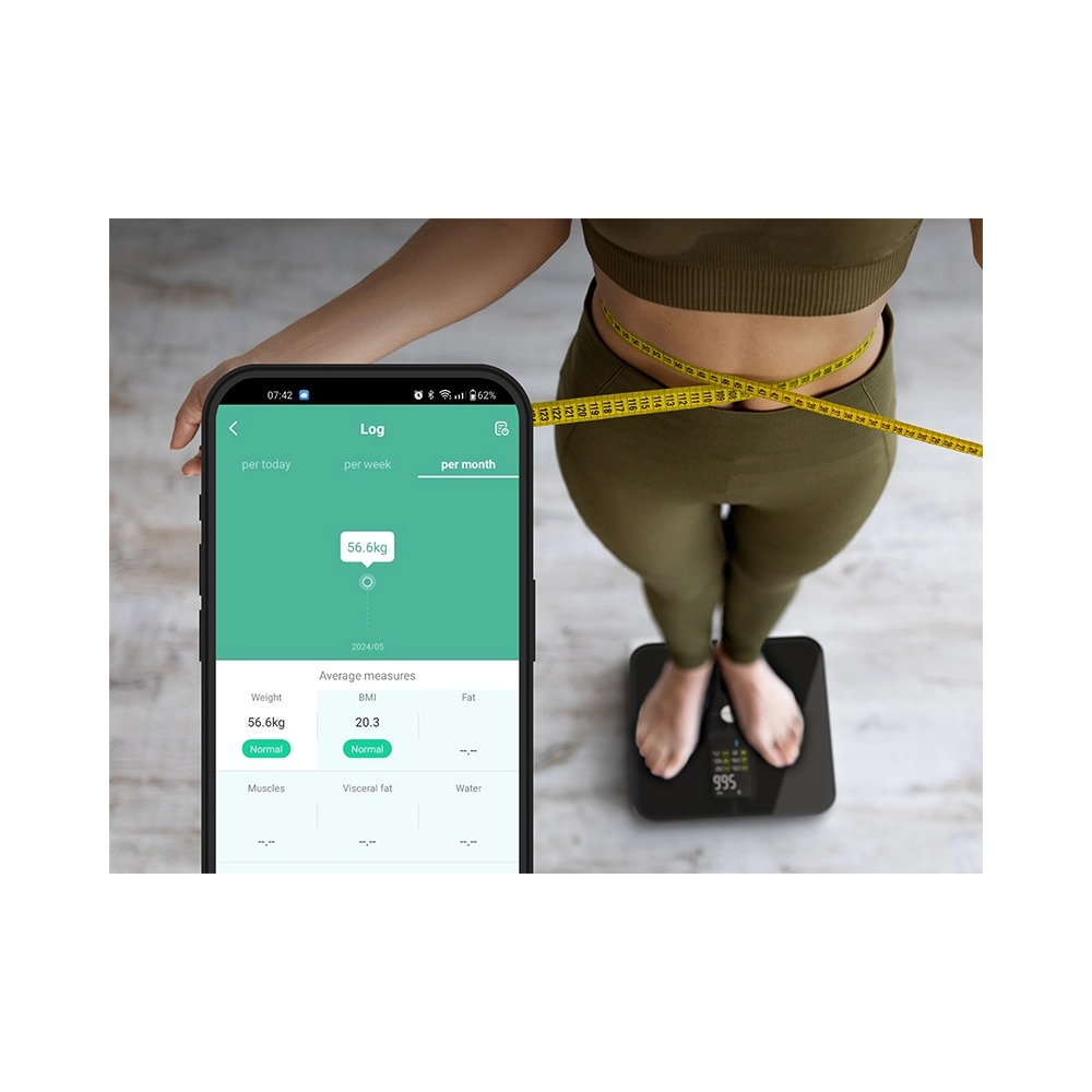 Kobieta w stroju sportowym stoi na wadze, podczas gdy smartfon wyświetla dane dziennika.