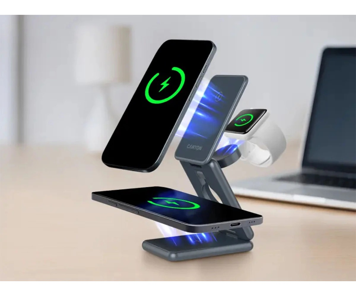 Wielourządzeniowa bezprzewodowa stacja ładująca na biurku ładuje dwa telefony i smartwatch, w tle laptop.