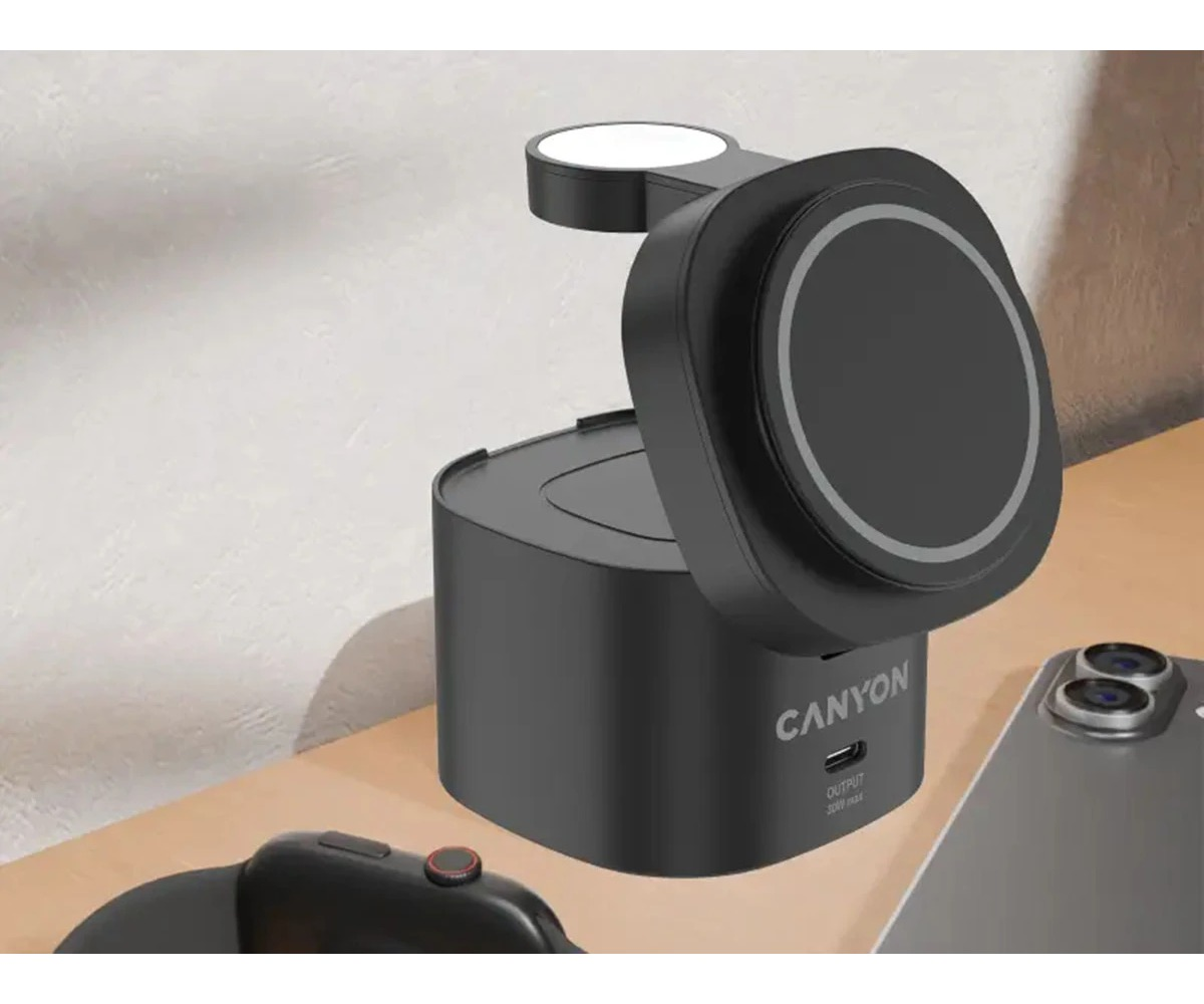 Czarna bezprzewodowa stacja ładująca Canyon stoi na drewnianym biurku obok smartfona.