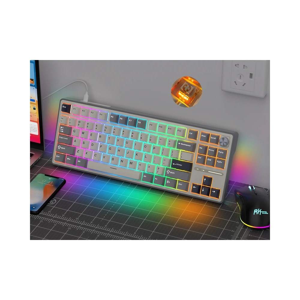 Szara klawiatura z podświetleniem RGB, mysz, smartfon i laptop na macie do cięcia.