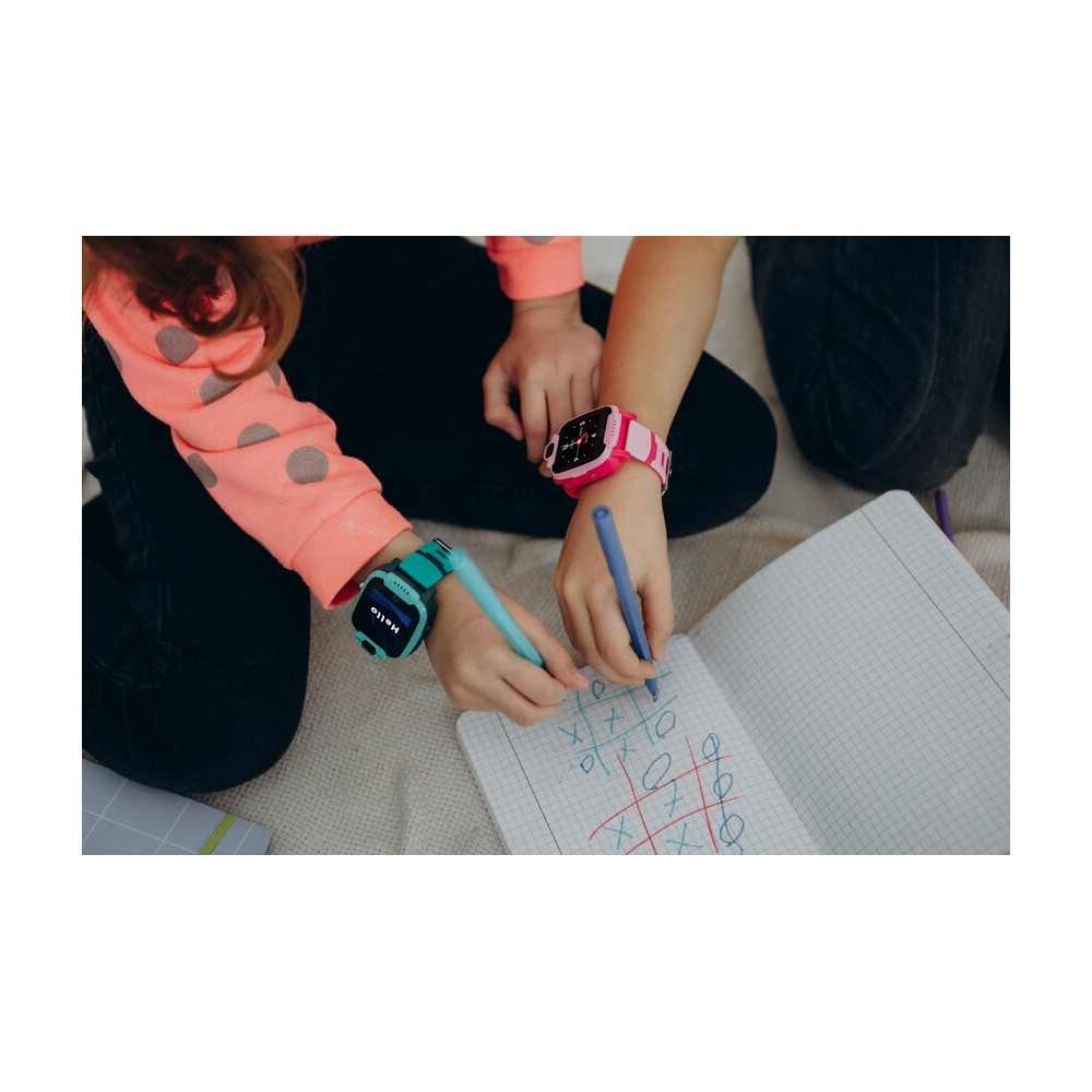 Dwoje dzieci w kolorowych smartwatchach gra w kółko i krzyżyk w zeszycie za pomocą mazaków.