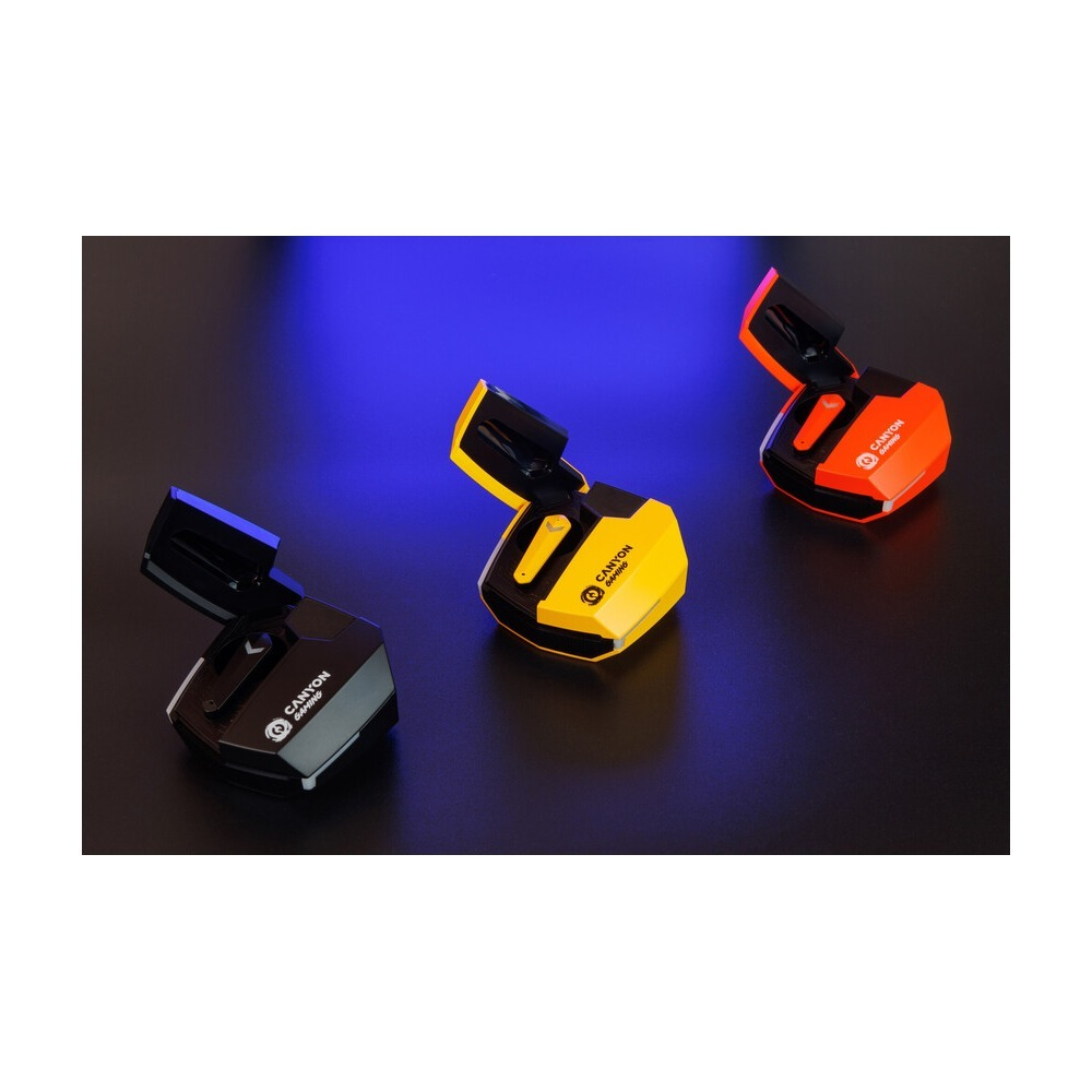 Drei Gaming-Earbuds-Ladeetuis in Schwarz, Gelb und Orange, offen auf dunkler Fläche mit blauem Hintergrundlicht.