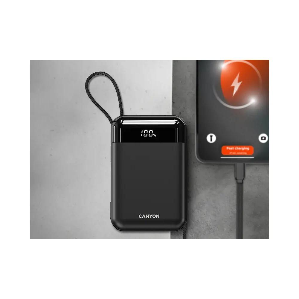 Czarny powerbank Canyon z cyfrowym wyświetlaczem pokazuje 100 procent obok szybko ładującego się smartfona.