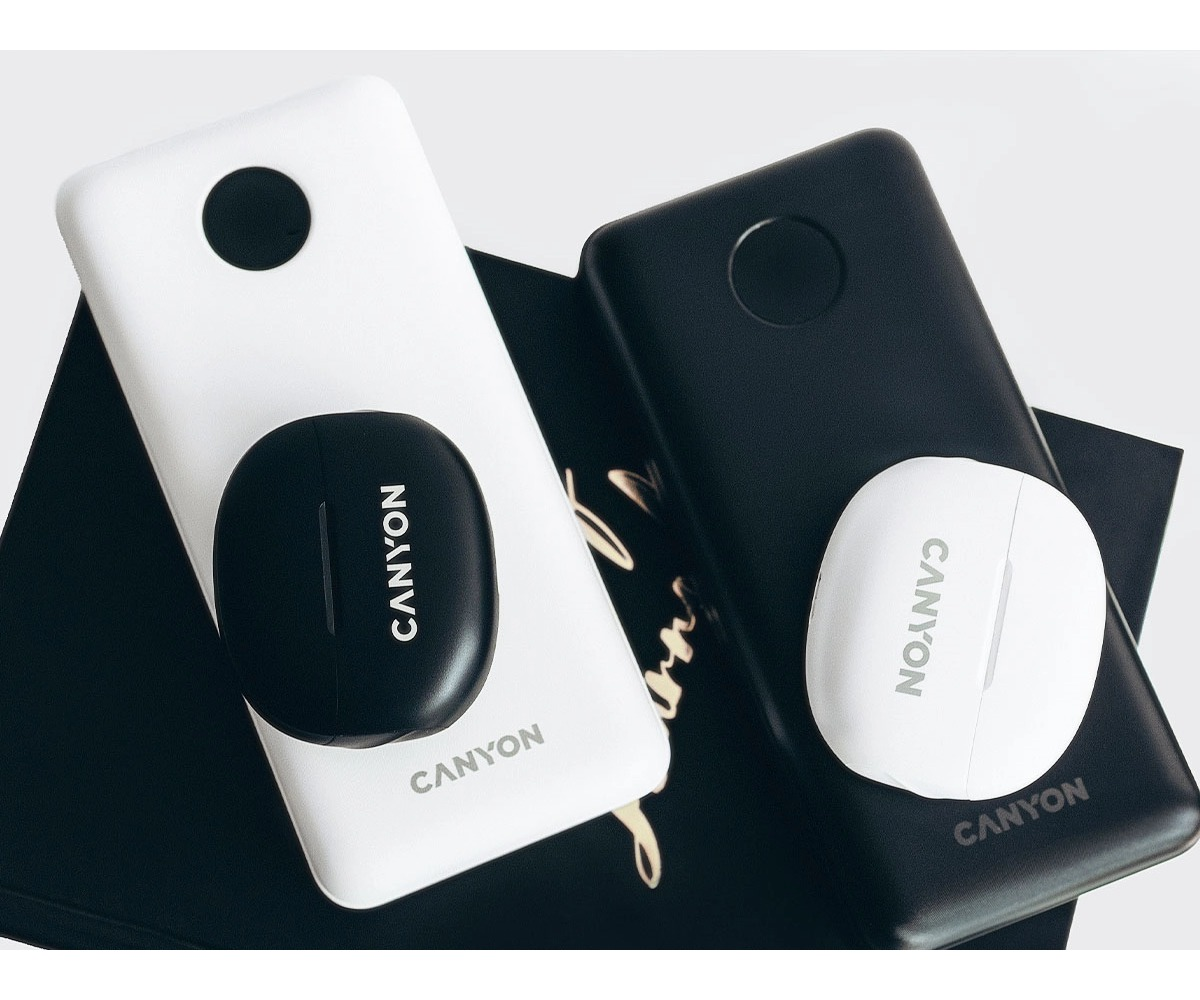 Biały powerbank z czarnym etui oraz czarny powerbank z białym etui na ciemnej powierzchni.