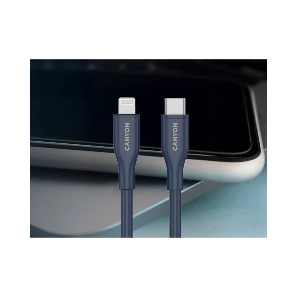 Dwa niebieskie kable Canyon ze złączami Lightning i USB-C przed laptopem.