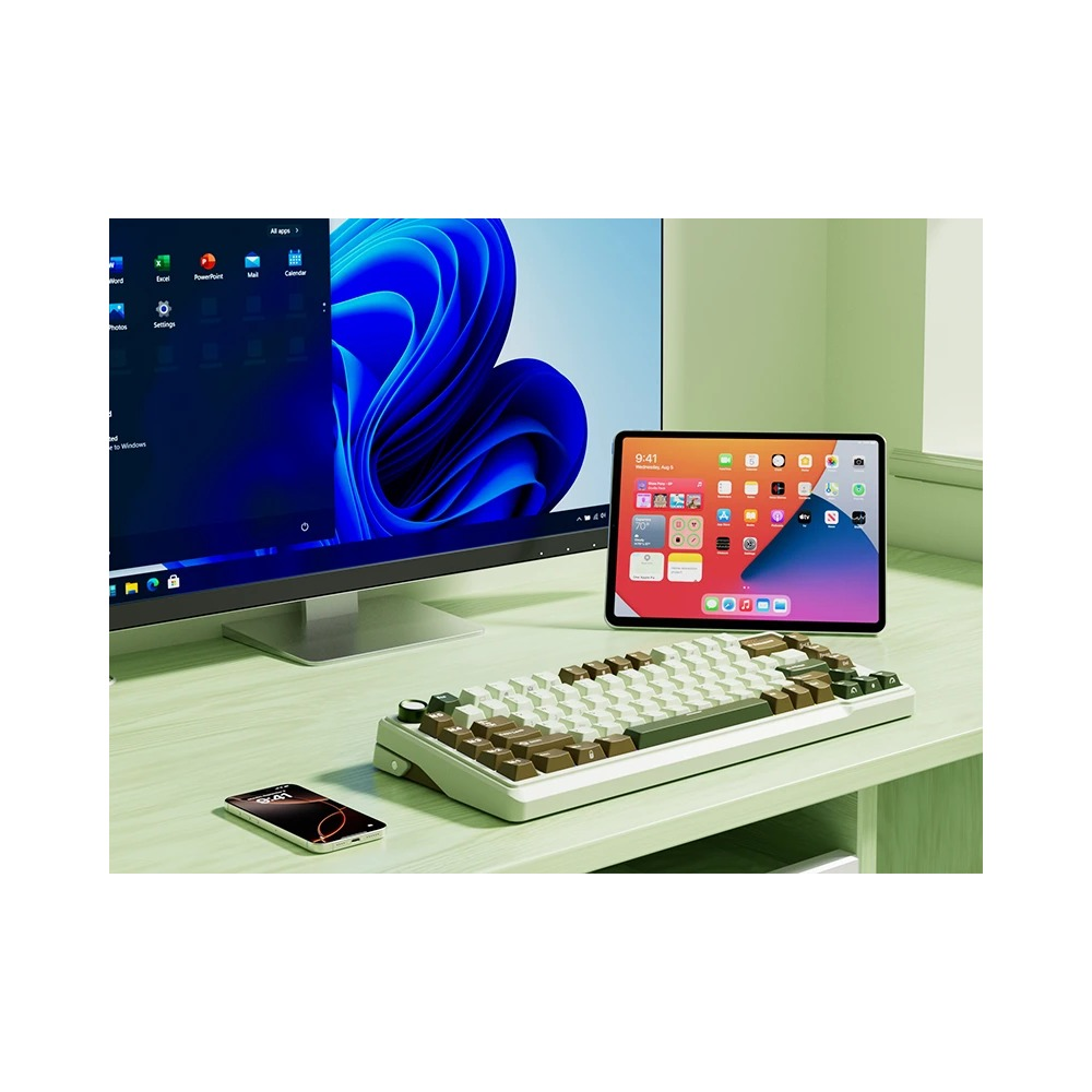 Biurko z monitorem, tabletem, brązowo-białą klawiaturą i smartfonem.