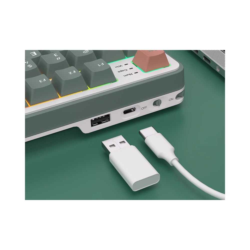 Zielono-biała klawiatura z portami USB i Type-C, biały adapter USB oraz kabel Type-C na zielonym biurku.