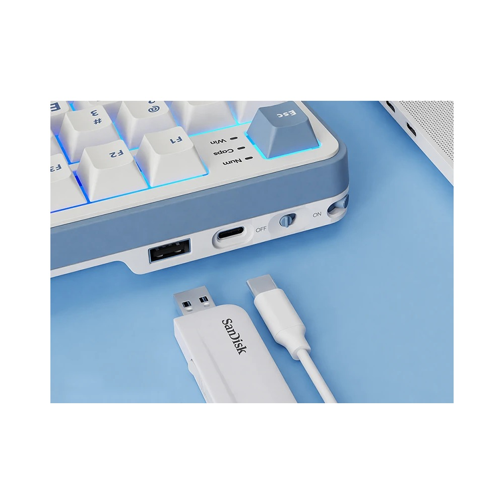 Niebiesko-biała klawiatura z portami, dyskiem USB i kablem na niebieskiej powierzchni.