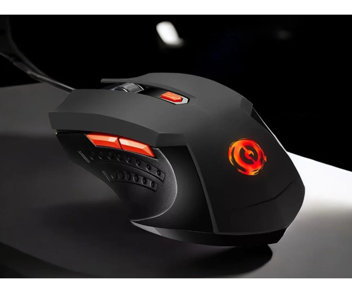 Un ratón de juego negro con detalles rojos y un logotipo iluminado en una superficie oscura.