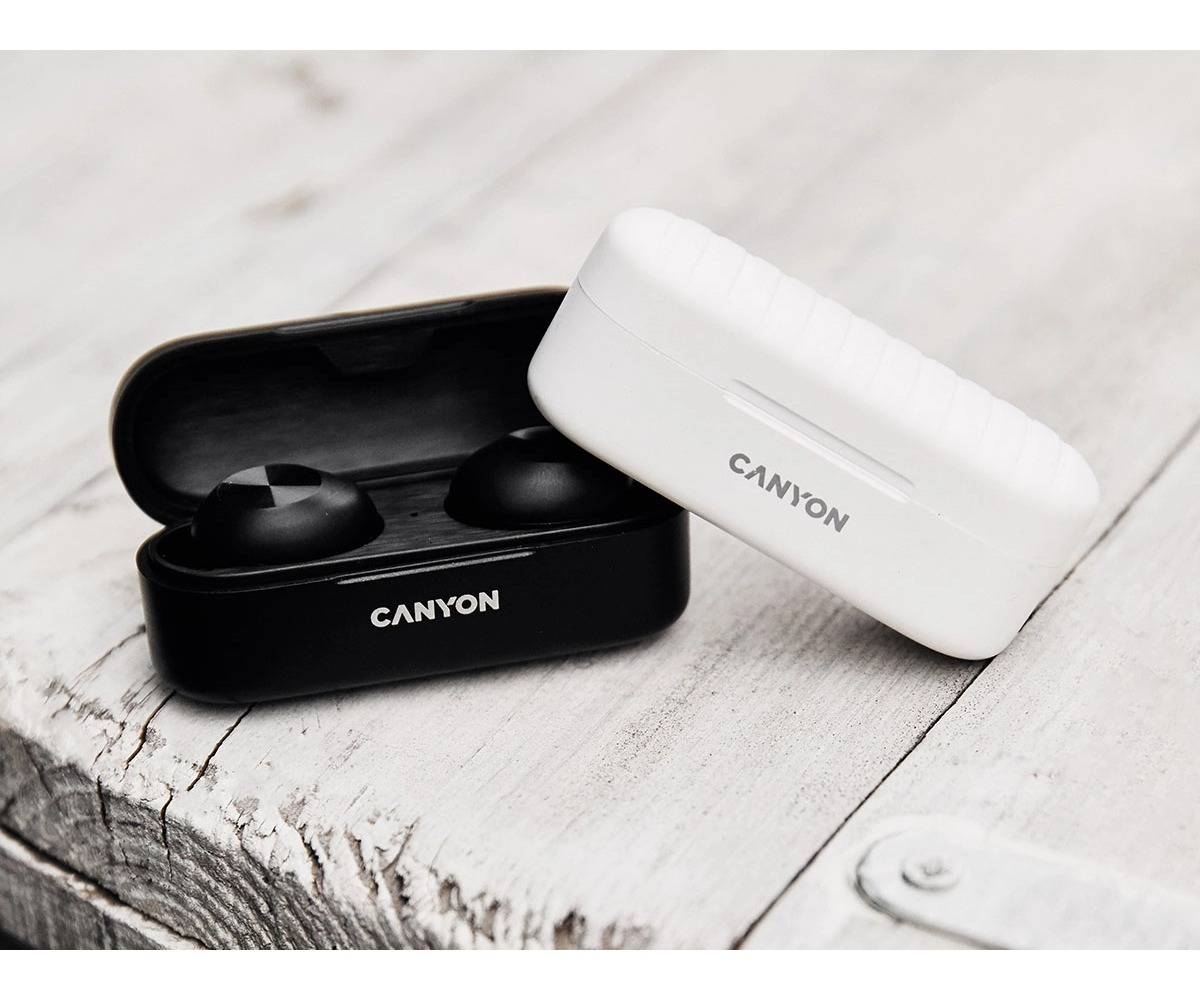 Dos estuches de carga de auriculares Canyon, uno blanco cerrado y otro negro abierto con auriculares.